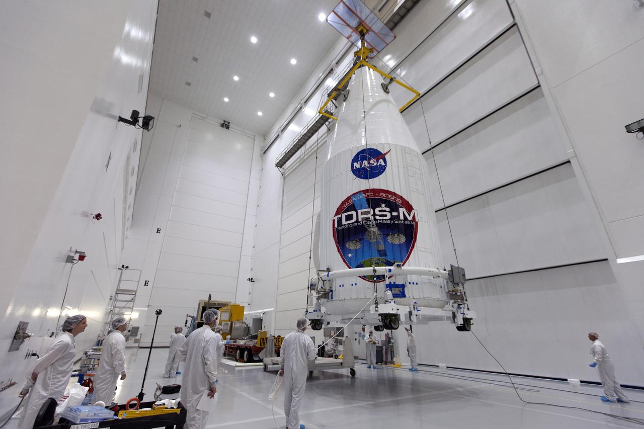 Inside the Astrotech facility near NASA's Kennedy Space Center in Florida, the agency's TDRS-M satellite, enclosed in its payload fairing, is lifted by crane and moved to a transport vehicle. The TDRS-M is the latest spacecraft destined for the agency's constellation of communications satellites that allows nearly continuous contact with orbiting spacecraft ranging from the International Space Station and Hubble Space Telescope to the array of scientific observatories. Liftoff atop a United Launch Alliance Atlas V rocket is scheduled to take place from Space Launch Complex 41 at Cape Canaveral Air Force Station on Aug. 18 at 8:03 a.m. EDT. 