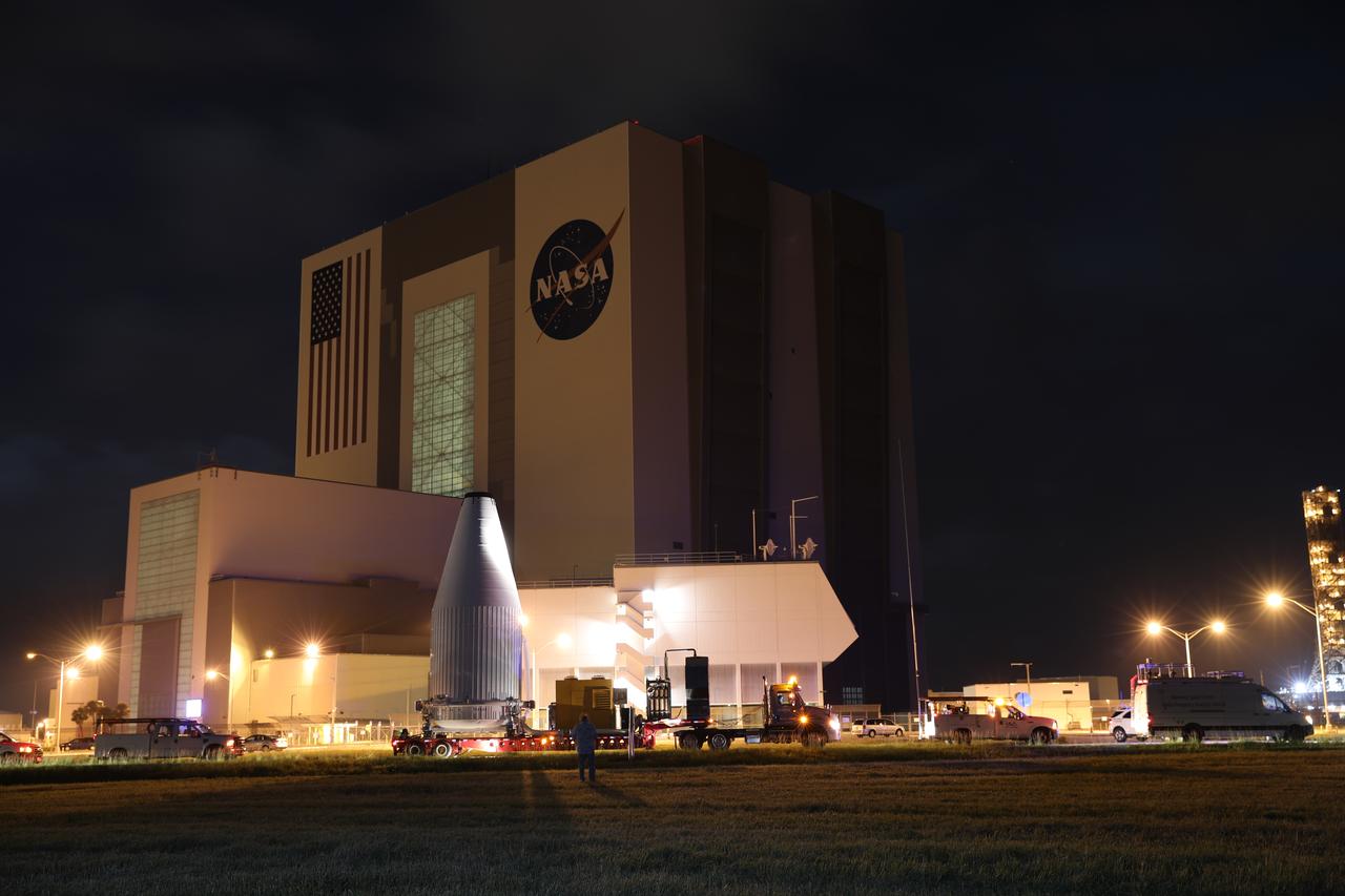 Enclosed in its payload fairing, NASA's Tracking and Data Relay Satellite (TDRS-M) passes the Vehicle assembly Building at the agency's Kennedy Space Center in Florida on its way to the Vertical Integration Facility at Space Launch Complex 41 at Cape Canaveral Air Force Station. TDRS-M will be stacked atop the United Launch Alliance Atlas V Centaur upper stage. It will be the latest spacecraft destined for the agency's constellation of communications satellites that allows nearly continuous contact with orbiting spacecraft ranging from the International Space Station and Hubble Space Telescope to the array of scientific observatories. Liftoff atop the ULA Atlas V rocket is scheduled to take place from Cape Canaveral's Space Launch Complex 41 on Aug. 18, 2017.