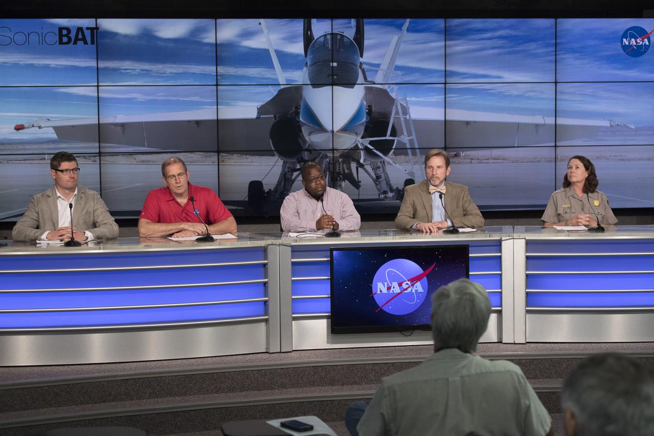 In the Kennedy Space Center's Press Site auditorium, NASA and other government leaders speak to members of the media at a news conference to discuss upcoming flight tests to study the effects of sonic booms. Participants from left are: Matthew Kamlet of NASA Communications at the Armstrong Flight Research Center in California; Peter Coen, SonicBAT Mission Analysis at NASA’s Langley Research Center in Virginia; Larry Cliatt, SonicBAT Fluid Mechanics at Armstrong; Dale Ketcham chief of Strategic Alliances for Space Florida; and Laura Henning, public information officer for the Canaveral National Seashore. Kennedy is partnering with Armstrong, Langley and Space Florida for a program called SonicBAT for Sonic Booms in Atmospheric Turbulence. Starting in August, NASA F-18 jets will take off from the Shuttle Landing Facility and fly at supersonic speeds while agency researchers on the ground measure the effects of low-altitude turbulence on sonic booms. The study could lead to technology mitigating the annoying sonic booms making possible supersonic flights over populated areas.