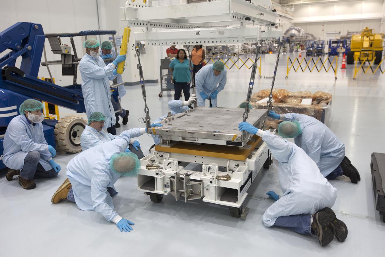 The Materials International Space Station Experiment-Flight Facility, or MISSE-FF, hardware arrived at the Space Station Processing Facility low bay at NASA's Kennedy Space Center in Florida. Technicians assist as one of the components is lowered onto another MISSE component. MISSE will be used to test various materials and computing elements on the exterior of the space station. They will be exposed to the harsh environment of low-Earth orbit, including to a vacuum, atomic oxygen, ultraviolet radiation, direct sunlight and extreme heat and cold. The experiment will provide a better understanding of material durability, from coatings to electronic sensors, which could be applied to future spacecraft designs. MISSE will be delivered to the space station on a future commercial resupply mission. 