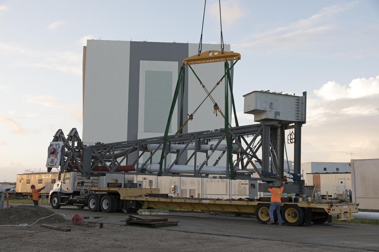 A heavy-lift crane has been attached to the Core Stage Inter-tank Umbilical (CSITU) to lift it up from a flatbed truck near the Vehicle Assembly Building at NASA's Kennedy Space Center in Florida. The CSITU will be lifted up to about the 140-foot level of the mobile launcher (ML) tower for a fit check of the attachment hardware. It will be lowered down and installed permanently on the ML at a later date. The CSITU is a swing-arm umbilical that will connect to the Space Launch System core stage inter-tank. It will provide conditioned air, pressurized gases and power and data connection to the core stage. The Ground Systems Development and Operations Program is overseeing installation of the umbilicals. 