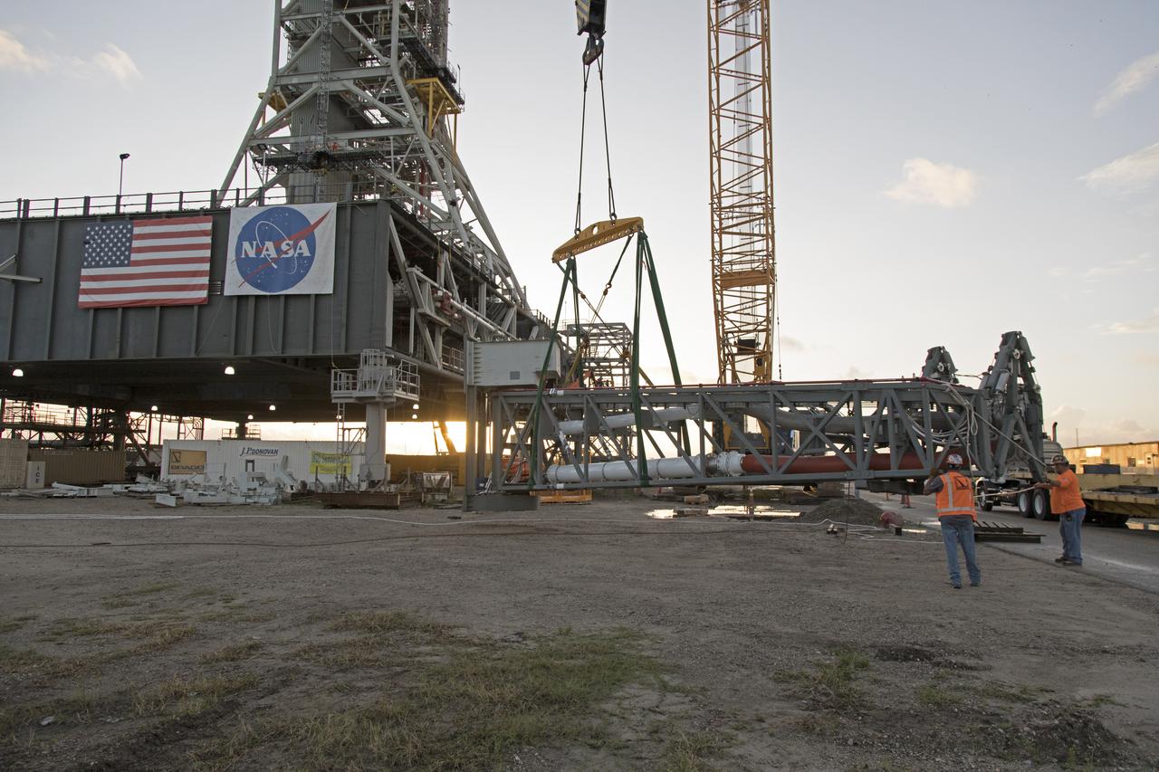 A heavy-lift crane has been attached to the Core Stage Inter-tank Umbilical (CSITU) to lift it up from a flatbed truck near the Vehicle Assembly Building at NASA's Kennedy Space Center in Florida. The CSITU will be lifted up to about the 140-foot level of the mobile launcher (ML) tower for a fit check of the attachment hardware. It will be lowered down and installed permanently on the ML at a later date. The CSITU is a swing-arm umbilical that will connect to the Space Launch System core stage inter-tank. It will provide conditioned air, pressurized gases and power and data connection to the core stage. The Ground Systems Development and Operations Program is overseeing installation of the umbilicals. 