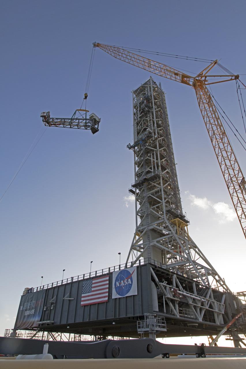 A heavy-lift crane and rigging are used to lift the Core Stage Inter-tank Umbilical (CSITU) up to about the 140-foot level of the mobile launcher (ML) tower at NASA's Kennedy Space Center in Florida. The CSITU will be moved into place for a fit check of the attachment hardware. The umbilical will be lowered down and installed permanently on the ML at a later date. The CSITU is a swing-arm umbilical that will connect to the Space Launch System core stage inter-tank. It will provide conditioned air, pressurized gases and power and data connection to the core stage. The Ground Systems Development and Operations Program is overseeing installation of the umbilicals. 
