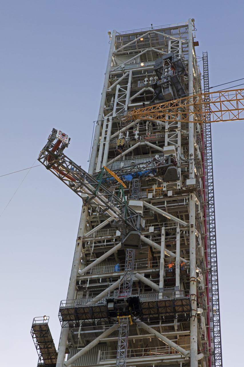 A heavy-lift crane moves the Core Stage Inter-tank Umbilical (CSITU) up to about the 140-foot level of the mobile launcher (ML) tower at NASA's Kennedy Space Center in Florida. The CSITU is moved into place for a fit check of the attachment hardware. The umbilical will be lowered down and installed permanently on the ML at a later date. The CSITU is a swing-arm umbilical that will connect to the Space Launch System core stage inter-tank. It will provide conditioned air, pressurized gases and power and data connection to the core stage. The Ground Systems Development and Operations Program is overseeing installation of the umbilicals.