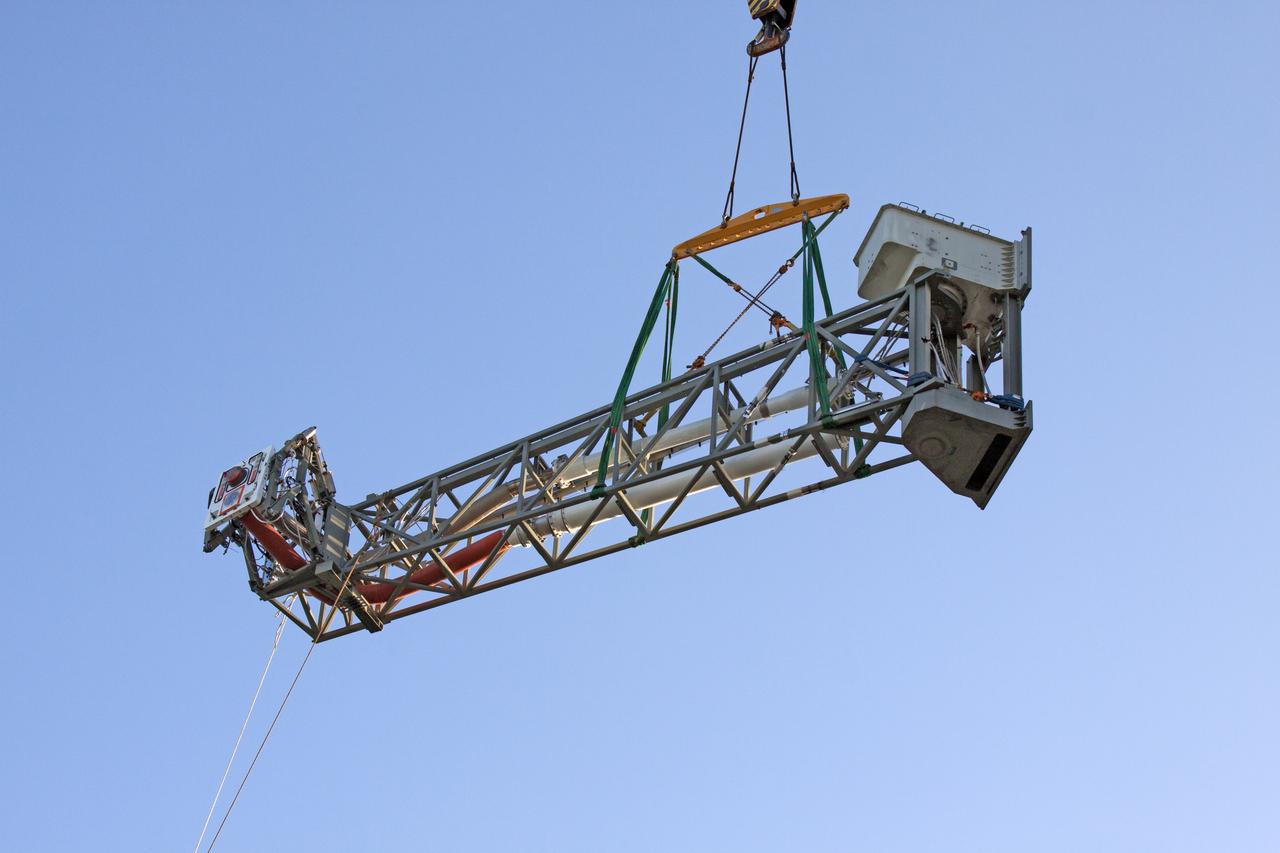 Seeming to hang in midair, the Core Stage Inter-tank Umbilical (CSITU) is lifted by crane and rigging up to about the 140-foot level of the mobile launcher (ML) tower at NASA's Kennedy Space Center in Florida. The CSITU will be moved into place for a fit check of the attachment hardware. The umbilical will be lowered down and installed permanently on the ML at a later date. The CSITU is a swing-arm umbilical that will connect to the Space Launch System core stage inter-tank. It will provide conditioned air, pressurized gases and power and data connection to the core stage. The Ground Systems Development and Operations Program is overseeing installation of the umbilicals. 