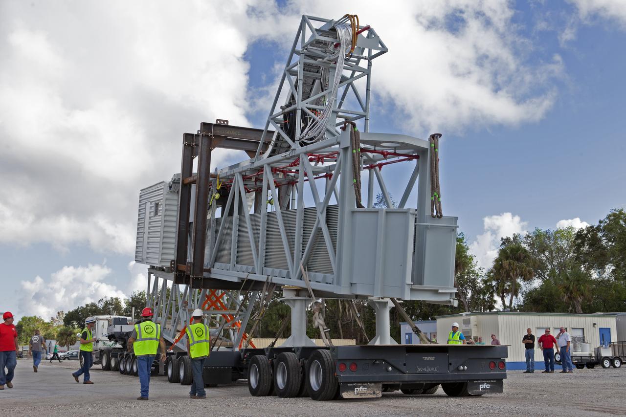 The Orion crew access arm is being secured onto a flatbed truck at Precision Fabricating and Cleaning in Cocoa, Florida. The crew access arm will be transported to a storage location near NASA's Kennedy Space Center in Florida. Later this month, the arm will be transported to the mobile launcher (ML) tower at the center. The crew access arm will be located at about the 274-foot level on the tower. It will rotate from its retracted position and interface with the Orion crew hatch location to provide entry to the Orion crew module. The Ground Systems Development and Operations Program is overseeing installation of umbilicals and launch accessories on the ML tower.