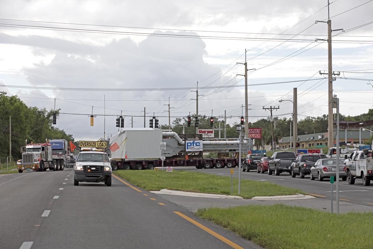 A flatbed truck with the Orion crew access arm secured atop travels along a road in Cocoa, Florida, after departing Precision Fabricating and Cleaning. The access arm will be transported to a storage location at NASA's Kennedy Space Center in Florida. Later this month, the arm will be transported to the mobile launcher (ML) tower at the center. The crew access arm will be located at about the 274-foot level on the tower. It will rotate from its retracted position and interface with the Orion crew hatch location to provide entry to the Orion crew module. The Ground Systems Development and Operations Program is overseeing installation of umbilicals and launch accessories on the ML tower. 