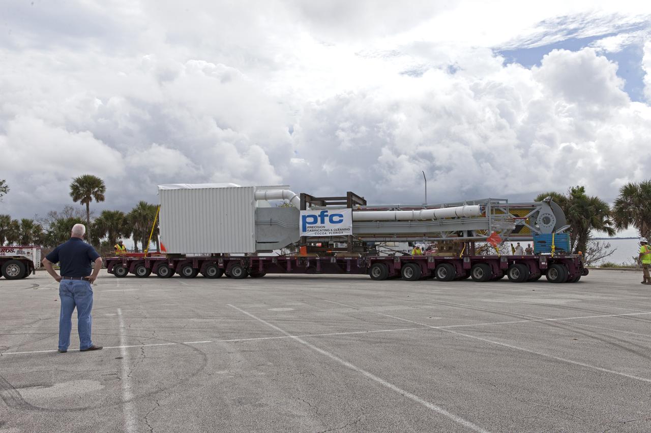 A flatbed truck with the Orion crew access arm secured atop arrives in a storage location at NASA's Kennedy Space Center in Florida. The access arm was transported from Precision Fabricating and Cleaning in Cocoa, Florida. Later this month, the arm will be transported to the mobile launcher (ML) tower at the center. The crew access arm will be located at about the 274-foot level on the tower. It will rotate from its retracted position and interface with the Orion crew hatch location to provide entry to the Orion crew module. The Ground Systems Development and Operations Program is overseeing installation of umbilicals and launch accessories on the ML tower.