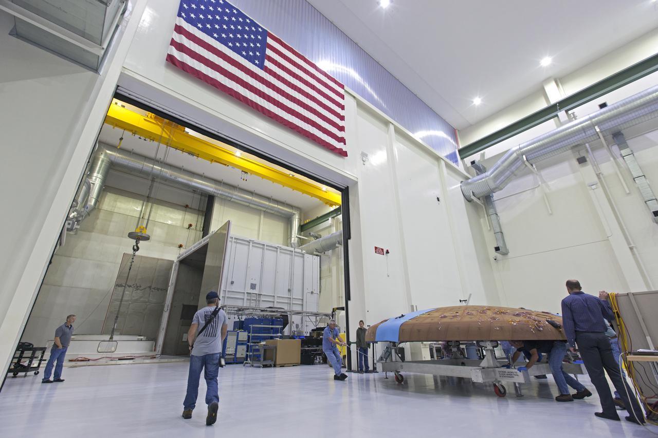 Technicians move the Orion heat shield for Exploration Mission-1 toward the thermal chamber in the Neil Armstrong Operations and Checkout Building high bay at NASA's Kennedy Space Center in Florida. Protective pads are being attached to the heat shield surface. The heat shield will undergo a thermal cycle test to verify acceptable workmanship and material quality. The test also serves to verify the heat shield's thermal protection systems have been manufactured and assembled correctly. The Orion spacecraft will launch atop NASA's Space Launch System rocket on its first uncrewed integrated flight.