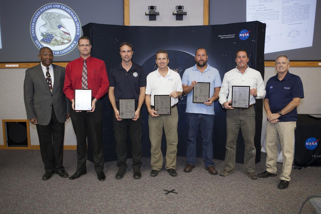 U.S. Patent plaques were awarded to, second from left, Mark Lewis, Adam Dokos, Robert Mueller, Jeffrey Carlson and Ivan Townsend III, for their invention, Dust Tolerant Connectors, during the 2017 Innovation Expo at NASA's Kennedy Space Center in Florida. Not pictured: Gary Basin, Matthew Branch, Kevin Murtland, Matthew Nugent and Gabor Tamasy. At left is Kelvin Manning, Kennedy's associate director. At far right is Dave Makufka, Kennedy's Technology Transfer Program manager. The purpose of the annual two-day expo is to help foster innovation and creativity among the Kennedy workforce. The event included several keynote speakers, training opportunities, an innovation showcase and the KSC Kickstart competition. 