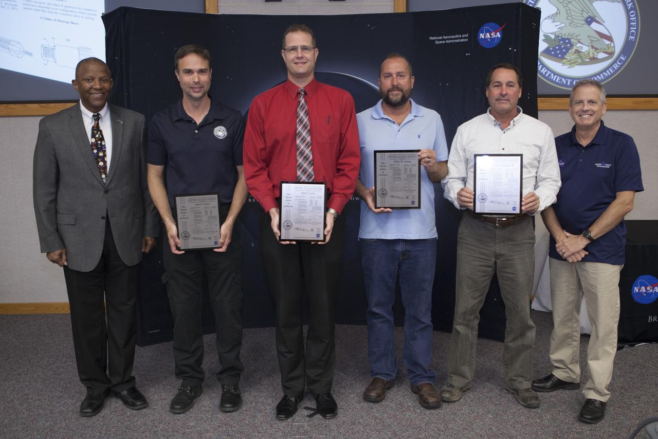 U.S. Patent plaques were awarded to, second from left, Adam Dokos, Mark Lewis, Jeffrey Carlson and Ivan Townsend III, for their invention, Dust and Debris Tolerant Retractable Cover, during the 2017 Innovation Expo at NASA's Kennedy Space Center in Florida. Not pictured: Gary Basin and Kevin Murtland. At left is Kelvin Manning, Kennedy's associate director. At far right is Dave Makufka, Kennedy's Technology Transfer Program manager. The purpose of the annual two-day expo is to help foster innovation and creativity among the Kennedy workforce. The event included several keynote speakers, training opportunities, an innovation showcase and the KSC Kickstart competition. 