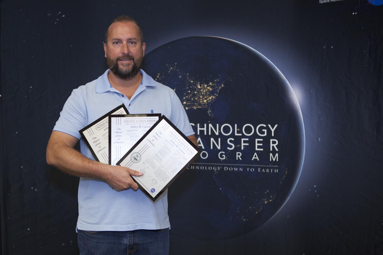 Jeffrey Carlson displays the three U.S. Patent plaques he received during a ceremony at the 2017 Innovation Expo at NASA's Kennedy Space Center in Florida. The purpose of the annual two-day expo is to help foster innovation and creativity among the Kennedy workforce. The event included several keynote speakers, training opportunities, an innovation showcase and the KSC Kickstart competition. 