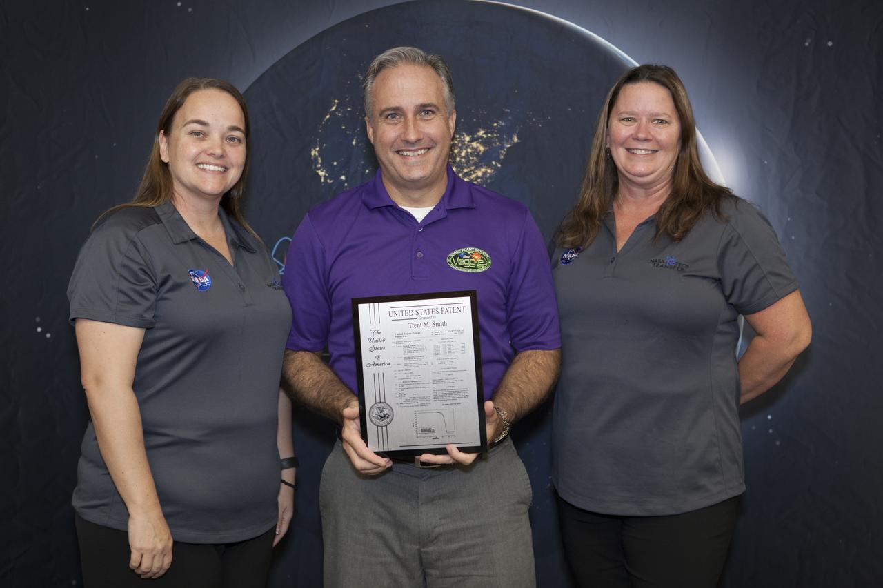 Trent Smith, project manager in the ISS Exploration Research and Technology Program, displays the U.S. Patent plaque he received during a ceremony at the 2017 Innovation Expo at NASA's Kennedy Space Center in Florida. The purpose of the annual two-day expo is to help foster innovation and creativity among the Kennedy workforce. The event included several keynote speakers, training opportunities, an innovation showcase and the KSC Kickstart competition. 