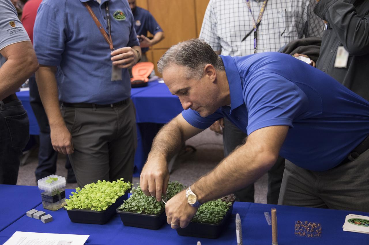 Trent Smith, a project manager in the ISS Exploration Research and Technology Program, displays microgreens grown in the same space dirt (arcillite) that is used in the plant pillows for the Veggie plant growth system on the International Space Station and in a 3-D-printed plastic matrix during the 2017 Innovation Expo showcase at NASA's Kennedy Space Center in Florida. The purpose of the annual two-day event is to help foster innovation and creativity among the Kennedy workforce. The event included several keynote speakers, training opportunities, an innovation showcase and the KSC Kickstart competition. 