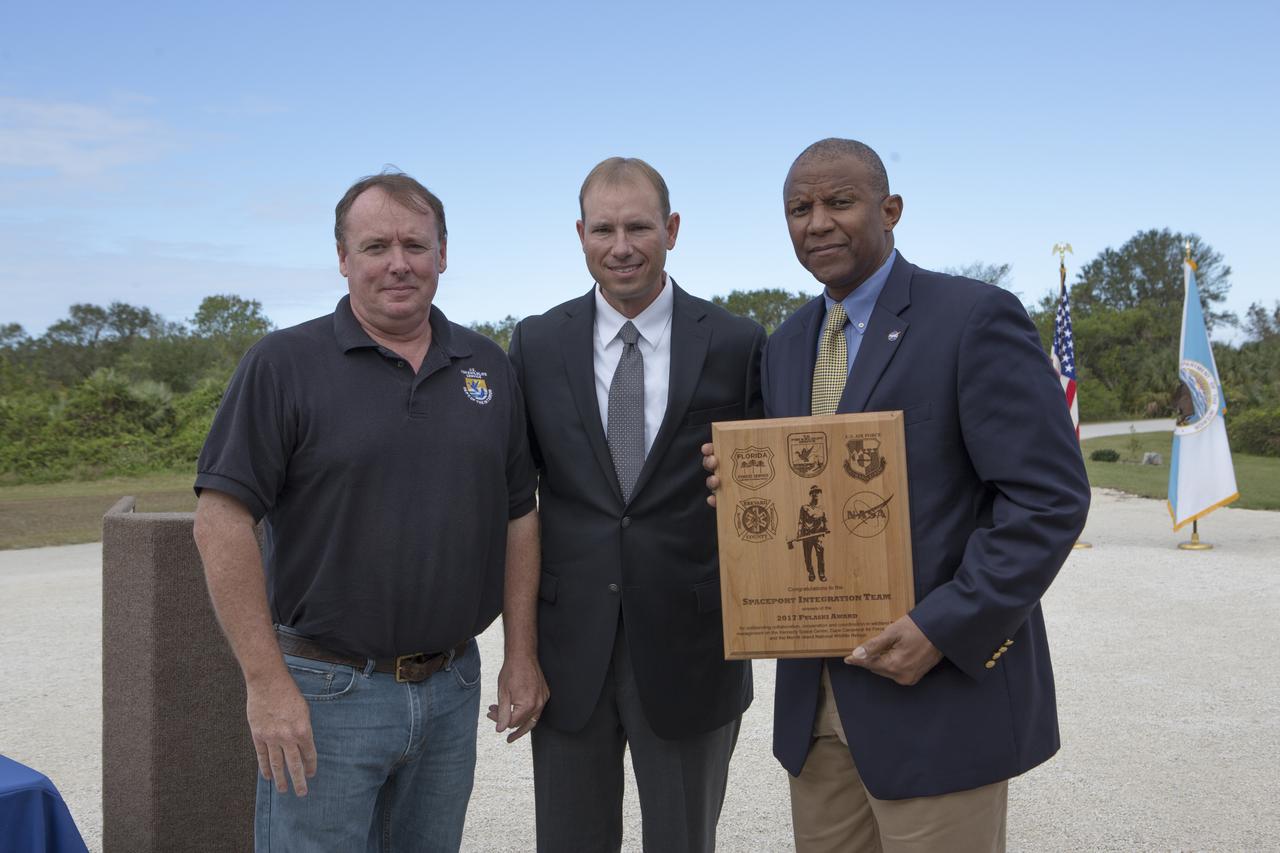 From left, Jon Wallace, deputy fire coordinator, U.S. Fish and Wildlife Service Southeast Region, Atlanta, Georgia; Chris Wilcox, U.S. Fish and Wildlife chief, Fire Management, National Interagency Fire Center, Boise, Idaho; and Kelvin Manning, associate director, NASA's Kennedy Space Center, pose for a portrait following a ceremony Nov. 1 on the Merritt Island National Wildlife Refuge in Florida. During the joint ceremony, the Spaceport Integration Team and its partners were presented with the prestigious 2017 Pulaski Award and a new memorial marker was dedicated. The multi-agency team includes representatives from NASA's Kennedy Space Center, Cape Canaveral Air Force Station's 45th Space Wing, the Merritt Island National Wildlife Refuge, as well as the Florida Forest Service and Brevard County Fire Rescue. The memorial marker honors two fallen firefighters, Scott Maness and Beau Sauselein, who died fighting a wildfire on space center property in 1981. Held outdoors, the ceremony was attended by 140 guests.
