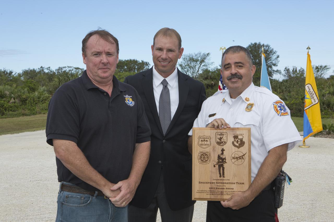 From left, Jon Wallace, deputy fire coordinator, U.S. Fish and Wildlife Service Southeast Region, Atlanta, Georgia; Chris Wilcox, U.S. Fish and Wildlife chief, Fire Management, National Interagency Fire Center, Boise, Idaho; and Mark Schollmeyer, chief, Brevard County Fire Rescue, pose for a portrait following a ceremony Nov. 1 on the Merritt Island National Wildlife Refuge in Florida. During the joint ceremony, the Spaceport Integration Team and its partners were presented with the prestigious 2017 Pulaski Award and a new memorial marker was dedicated. The multi-agency team includes representatives from NASA's Kennedy Space Center, Cape Canaveral Air Force Station's 45th Space Wing, the Merritt Island National Wildlife Refuge, as well as the Florida Forest Service and Brevard County Fire Rescue. The memorial marker honors two fallen firefighters, Scott Maness and Beau Sauselein, who died fighting a wildfire on space center property in 1981. Held outdoors, the ceremony was attended by 140 guests.