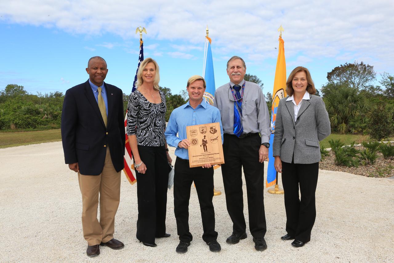 NASA's Kennedy Space Center Associate Director Kelvin Manning, left, and representatives from Kennedy's Spaceport Integration and Services pose for a portrait following a ceremony Nov. 1 on the Merritt Island National Wildlife Refuge in Florida. Next to Manning are, from left, Nancy Bray, director; William Heidtman, Spaceport Integrator; Dan Tweed, deputy director, Technical; and Jean Flowers, chief, Customer Services and Integration Branch. During the joint ceremony, the Spaceport Integration Team and its partners were presented with the prestigious 2017 Pulaski Award and a new memorial marker was dedicated. The multi-agency team includes representatives from NASA's Kennedy Space Center, Cape Canaveral Air Force Station's 45th Space Wing, the Merritt Island National Wildlife Refuge, as well as the Florida Forest Service and Brevard County Fire Rescue. The memorial marker honors two fallen firefighters, Scott Maness and Beau Sauselein, who died fighting a wildfire on space center property in 1981. Held outdoors, the ceremony was attended by 140 guests.
