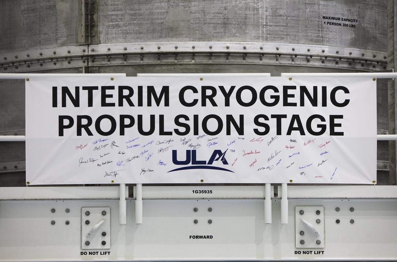 Several employees at NASA's Kennedy Space Center in Florida signed the banner at the base of the platform holding the Interim Cryogenic Propulsion Stage (ICPS) which stands inside the high bay of the Space Station Processing Facility. The ICPS is the first integrated piece of flight hardware to arrive in preparation for the uncrewed Exploration Mission-1. With the Orion attached, the ICPS sits atop the SLS rocket and will provide the spacecraft with the additional thrust needed to travel tens of thousands of miles beyond the Moon.