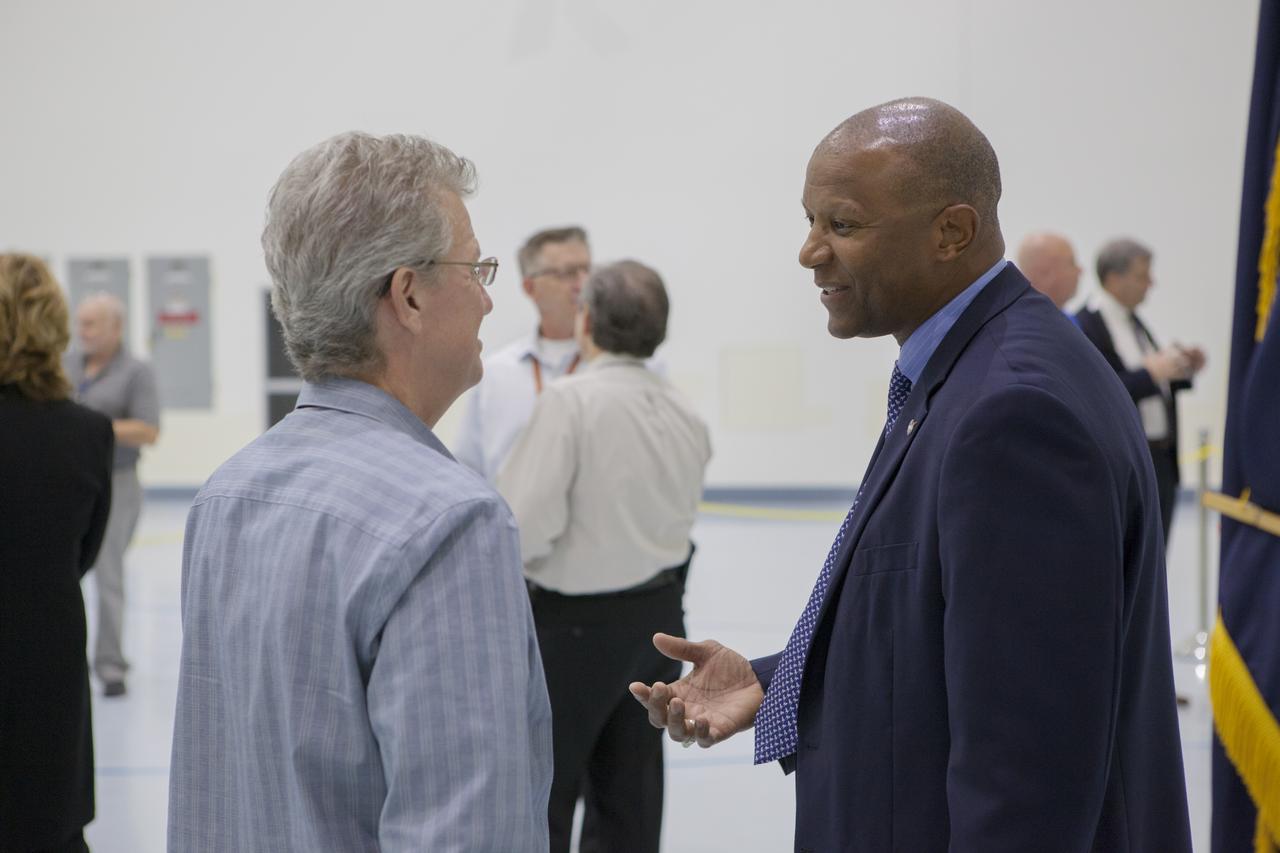 Kennedy Space Center Associate Director Kelvin Manning, right, speaks with a guest during a ceremony  marking NASA's Spacecraft/Payload Integration and Evolution (SPIE) organization formally turning over processing of the Space Launch System (SLS) rocket's Interim Cryogenic Propulsion Stage (ICPS) to the center's Ground Systems Development and Operations (GSDO) Directorate. The ICPS is the first integrated piece of flight hardware to arrive in preparation for the uncrewed Exploration Mission-1. With the Orion attached, the ICPS sits atop the SLS rocket and will provide the spacecraft with the additional thrust needed to travel tens of thousands of miles beyond the Moon.