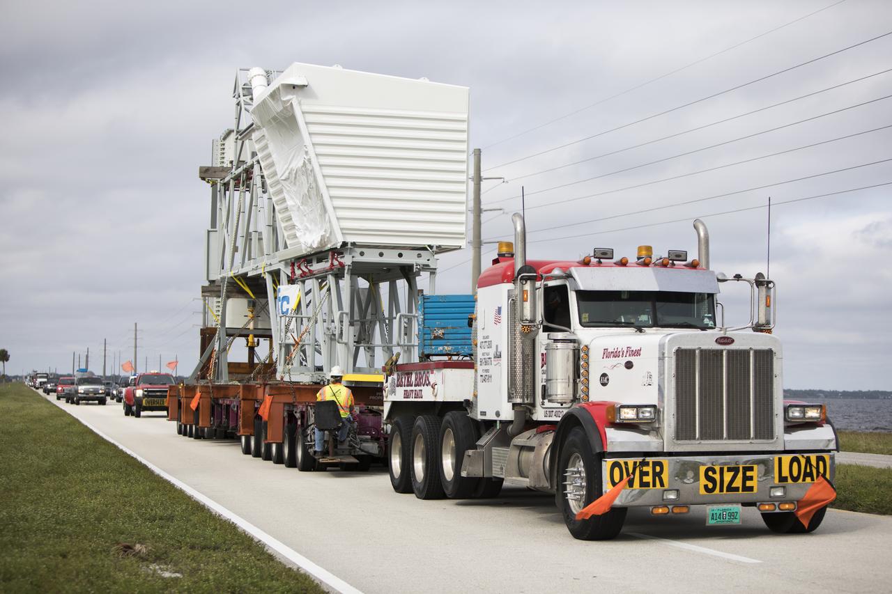 A heavy-load transport truck carries the Orion crew access arm along the NASA Causeway east toward State Road 3 at NASA's Kennedy Space Center in Florida. The access arm will be moved to the mobile launcher (ML) near the Vehicle Assembly Building at the center. The crew access arm will be installed at about the 274-foot level on the tower. It will rotate from its retracted position and interface with the Orion crew hatch location to provide entry to the Orion crew module. The Ground Systems Development and Operations Program is overseeing installation of umbilicals and launch accessories on the ML tower to prepare for Exploration Mission-1.