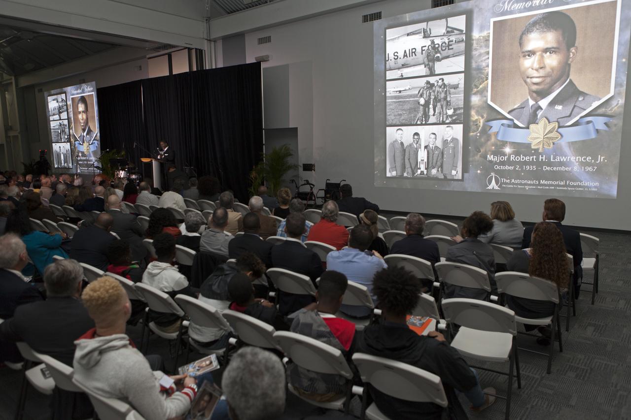 During an Astronauts Memorial Foundation tribute honoring U.S. Air Foce Maj. Robert Lawrence, photographs are projected during a video presentation. Selected in 1967 for the Manned Orbiting Laboratory Program, Lawrence was the first African-American astronaut. He lost his life in a training accident 50 years ago. The ceremony took place in the Center for Space Education at the Kennedy Space Center Visitor Complex.