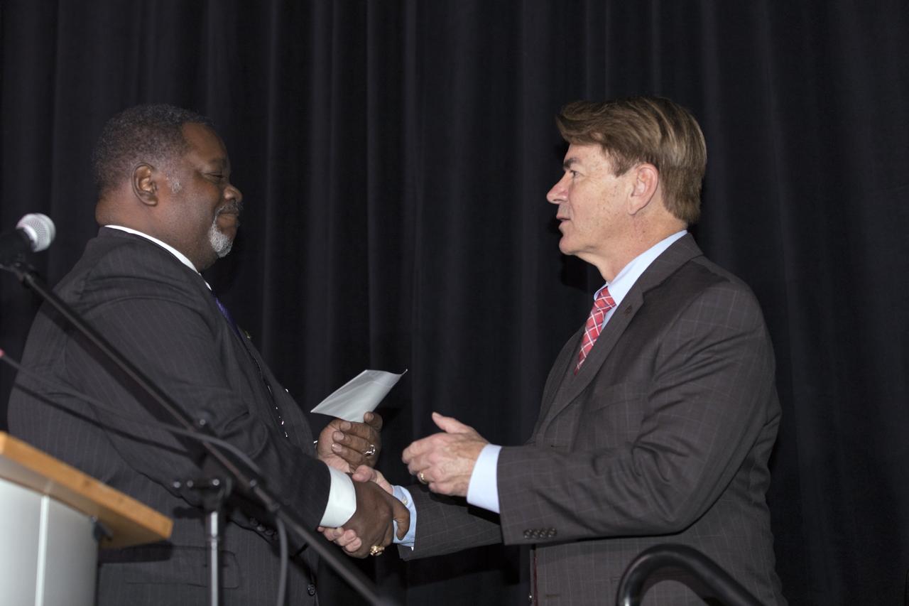 Antonio "Tony" Knox, grand basileus of the Omega Psi Phi farternity, makes a presentation to the Astronauts Memorial Foundation (AMF) with State Rep. Thad Altman, AMF president, accepting on behalf of the organization. The presentation took palce during an AMF tribute honoring U.S. Air Foce Maj. Lawrence who was a member of the fraternity. Selected in 1967 for the Manned Orbiting Laboratory Program, Lawrence was the first African-American astronaut. He lost his life in a training accident 50 years ago. The ceremony took place in the Center for Space Education at the Kennedy Space Center Visitor Complex.