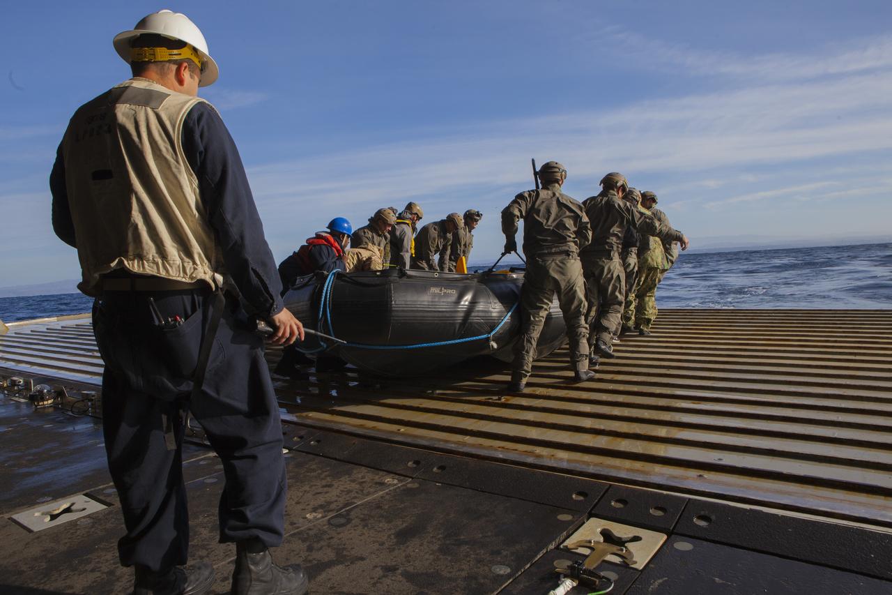 Chief Warrant Officer Ferrari from the USS Anchorage watches over members of the U.S. Navy’s Mobile Diving Salvage Co. 3-1 as they set off to sea to recover the Orion test capsule during Underway Recovery Test 6 off the coast of San Diego. Kennedy Space Center’s NASA Recovery Team works with the U.S. Navy to improve recovery procedures and hardware ahead of Orion's next flight, Exploration Mission-1, when it splashes down in the Pacific Ocean.