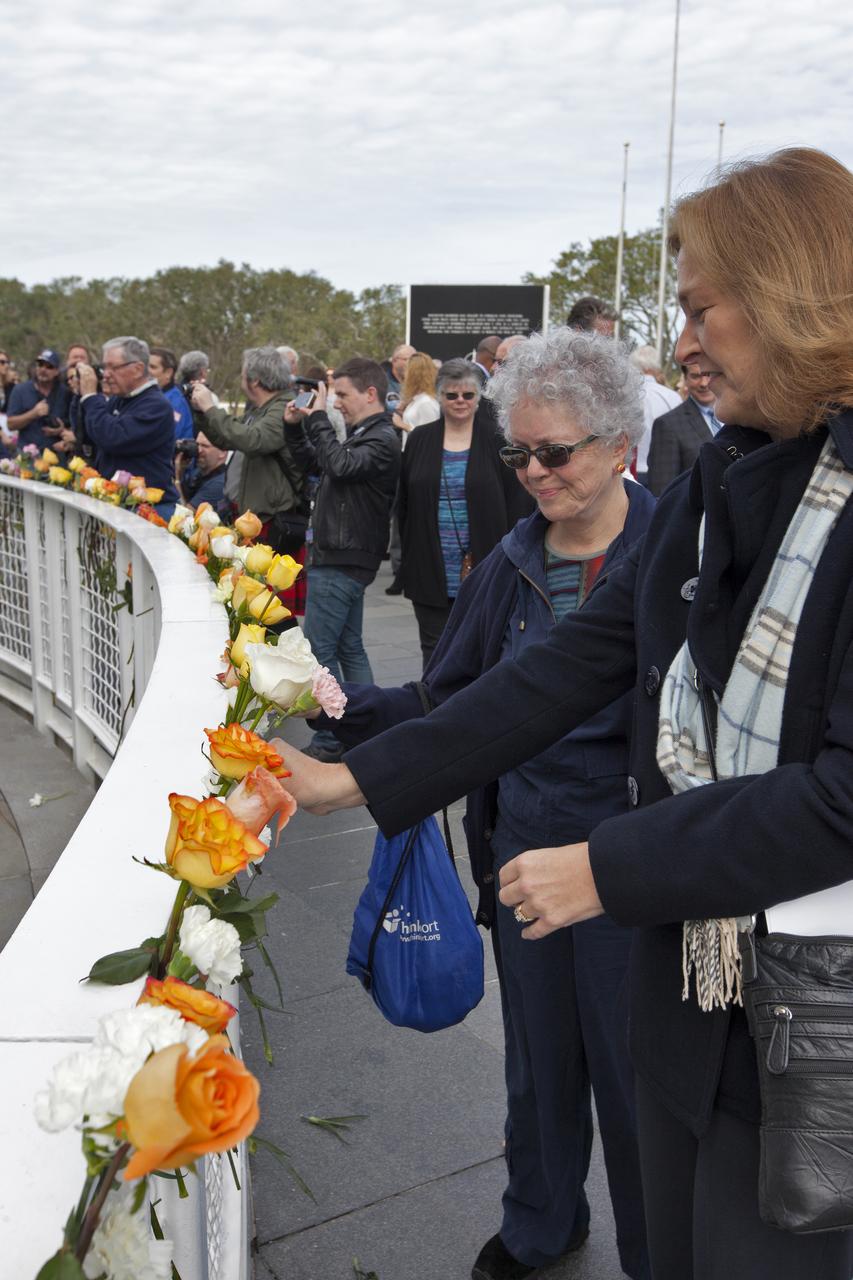 Guests place flowers near the Space Mirror Memorial at the Kennedy Space Center Visitor Complex. The names of fallen astronauts from Apollo 1, Challenger and Columbia, as well as the astronauts who perished in training and commercial airplane accidents are emblazoned on the monument. During the annual Day of Remembrance, spaceport employees and guests join others throughout NASA honoring the contributions of astronauts who have perished in the conquest of space.