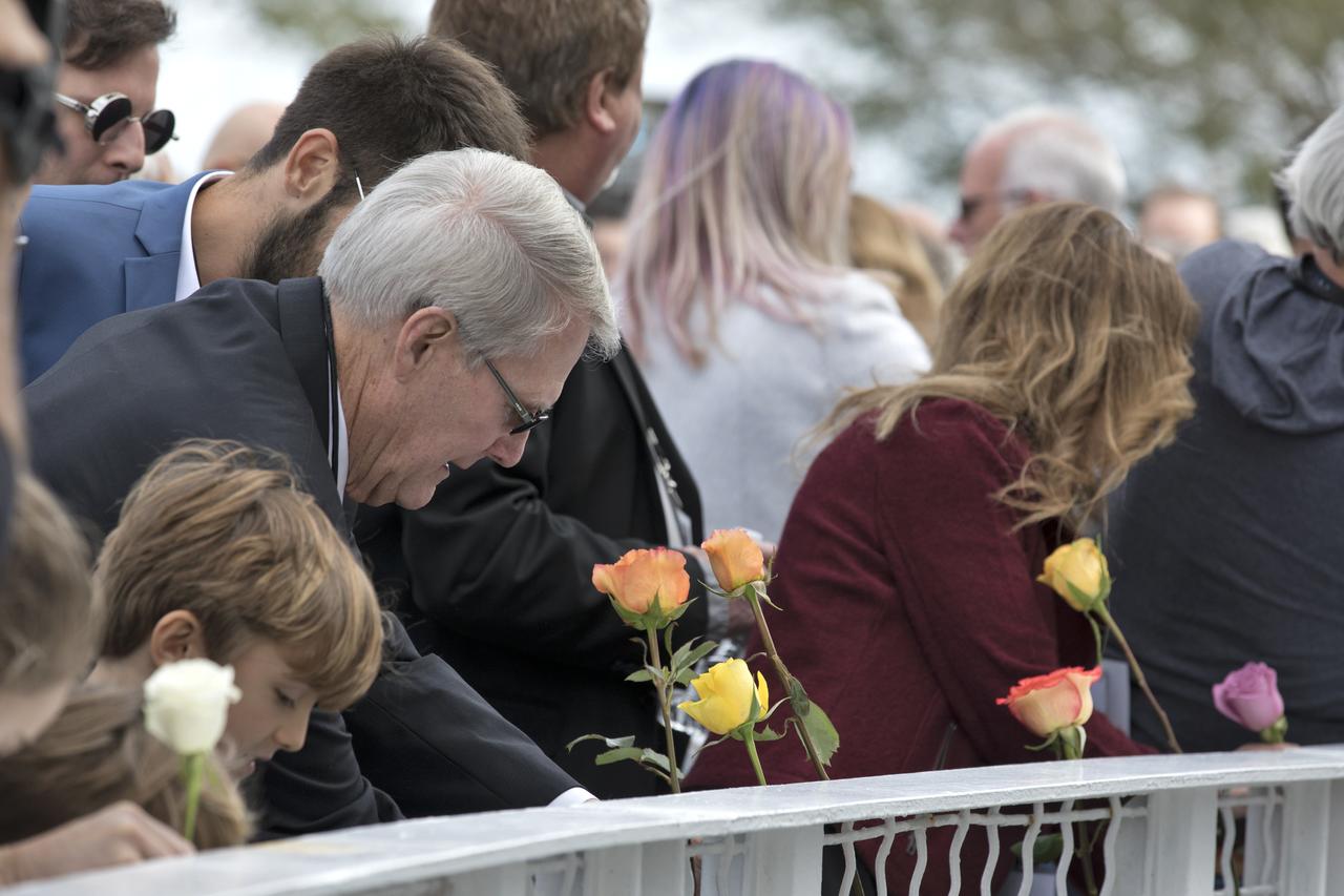 Guests place flowers near the Space Mirror Memorial at the Kennedy Space Center Visitor Complex. The names of fallen astronauts from Apollo 1, Challenger and Columbia, as well as the astronauts who perished in training and commercial airplane accidents are emblazoned on the monument. During the annual Day of Remembrance, spaceport employees and guests join others throughout NASA honoring the contributions of astronauts who have perished in the conquest of space.