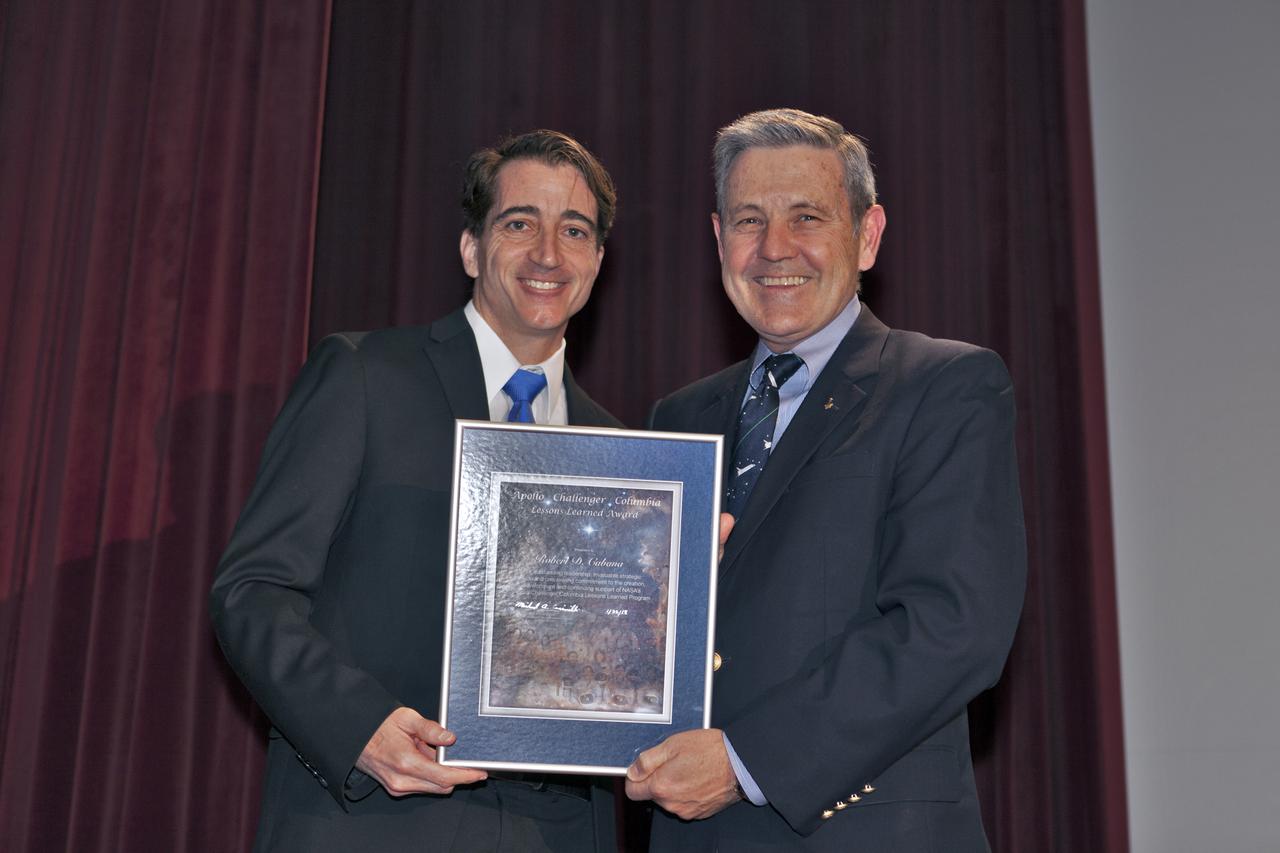 Mike Ciannilli, left, manager of the Apollo, Challenger, Columbia Lessons Learned Program (ACCLLP), presents a certificate of appreciation to Kennedy Space Center Director Bob Cabana, during an ACCLLP employee event in the Training Auditorium at the center in Florida. The theme of the presentation was "Columbia: Lessons and Legends of Recovery," and featured a panel discussion moderated by Cabana. 