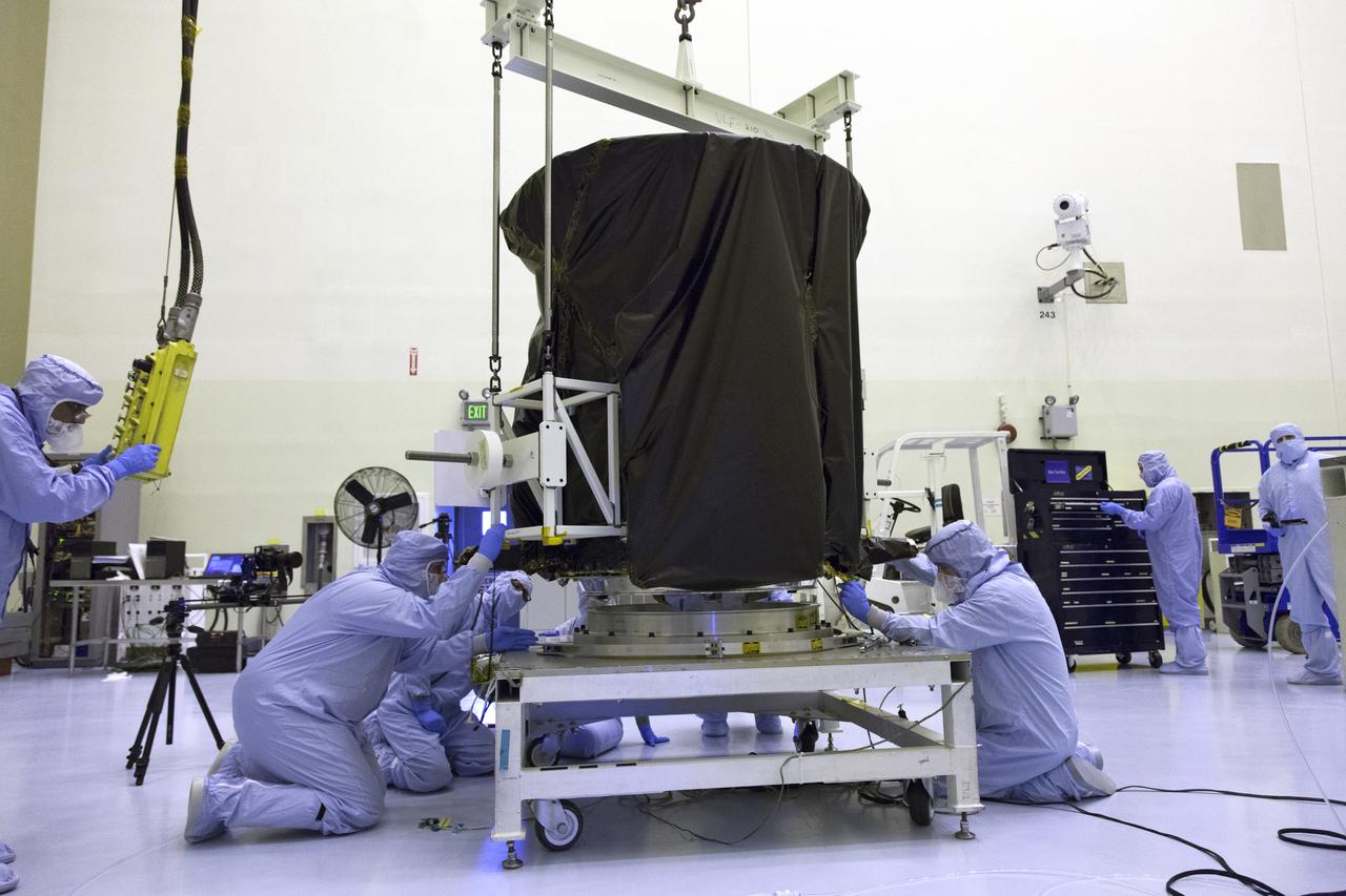 Technicians dressed in clean room suits monitor the progress as a crane lowers NASA's Transiting Exoplanet Survey Satellite (TESS) onto a test stand inside the Payload Hazardous Servicing Facility (PHSF) at the agency's Kennedy Space Center in Florida. Inside the PHSF, the satellite will be processed and prepared for its flight. TESS is scheduled to launch atop a SpaceX Falcon 9 rocket from Space Launch Complex 40 at Cape Canaveral Air Force Station. TESS is the next step in NASA's search for planets outside our solar system, known as exoplanets. TESS is a NASA Astrophysics Explorer mission led and operated by MIT in Cambridge, Massachusetts, and managed by NASA’s Goddard Space Flight Center in Greenbelt, Maryland. Dr. George Ricker of MIT’s Kavli Institute for Astrophysics and Space Research serves as principal investigator for the mission. Additional partners include Orbital ATK, NASA’s Ames Research Center, the Harvard-Smithsonian Center for Astrophysics and the Space Telescope Science Institute. More than a dozen universities, research institutes and observatories worldwide are participants in the mission. NASA’s Launch Services Program is responsible for launch management. 