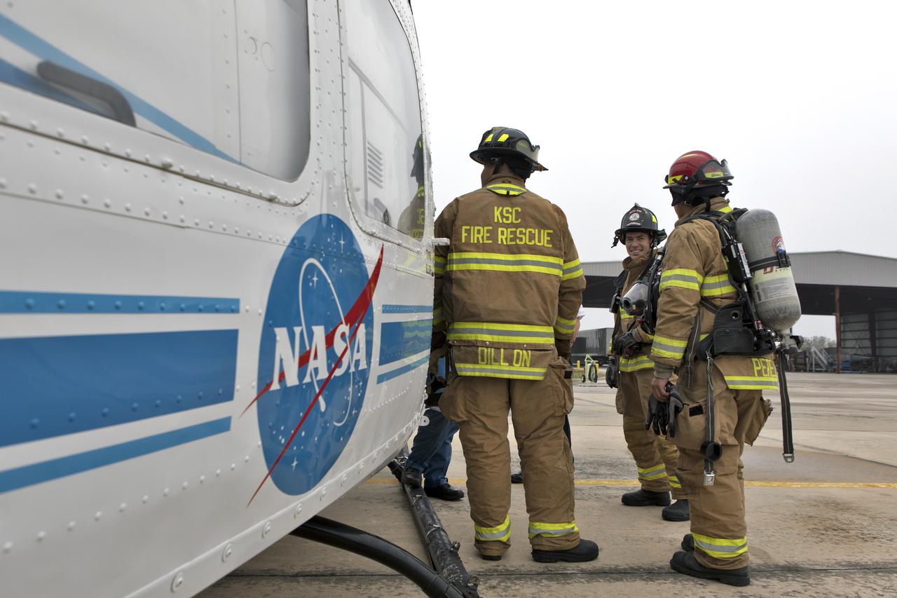 Members of NASA Kennedy Space Center's Flight Operations team prepare for a rehearsal of a helicopter crash-landing to test new and updated emergency procedures. Called the Aircraft Mishap Preparedness and Contingency Plan, the operation was designed to validate several updated techniques the center's first responders would follow, should they ever need to rescue a crew in case of a real accident. The mishap exercise took place at the center's Shuttle Landing Facility. 