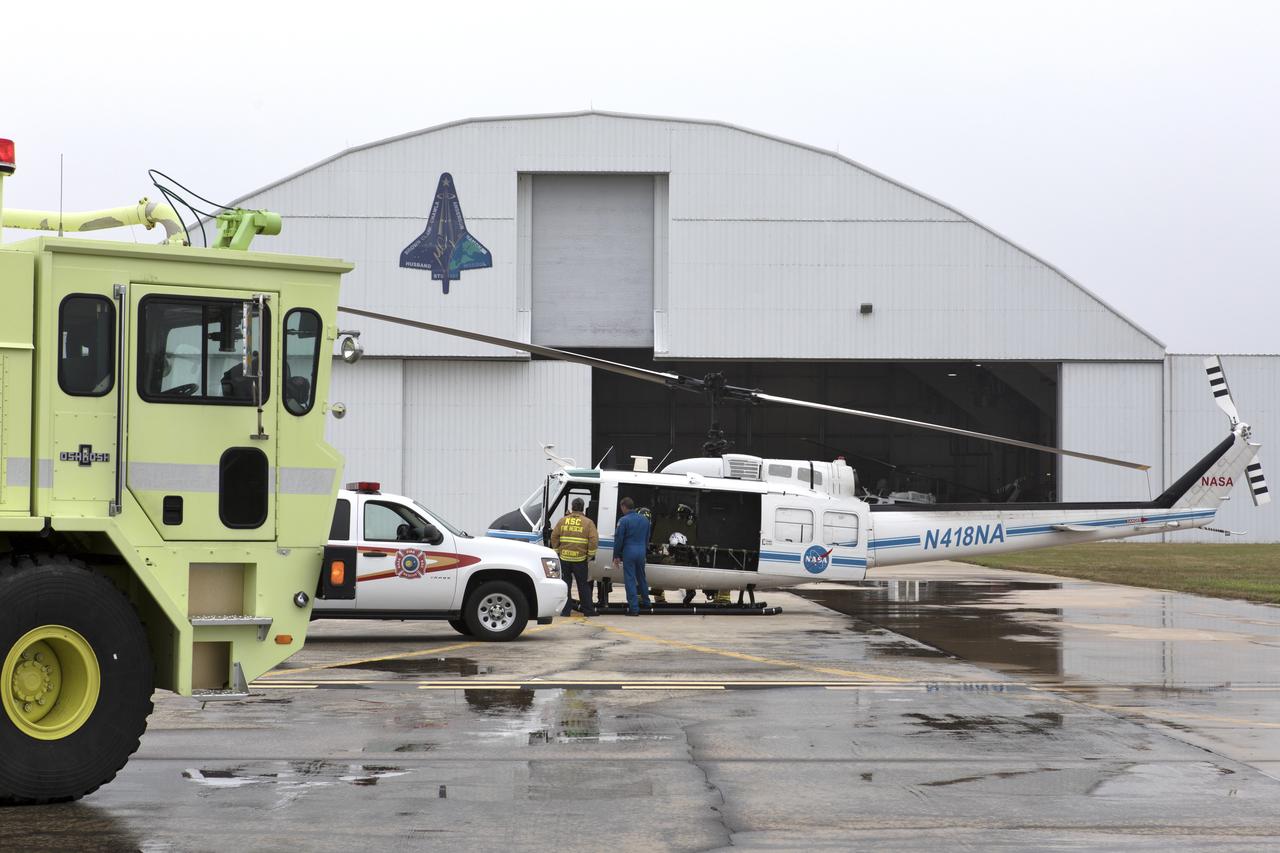 Members of NASA Kennedy Space Center's Flight Operations team prepare for a rehearsal of a helicopter crash-landing to test new and updated emergency procedures. Called the Aircraft Mishap Preparedness and Contingency Plan, the operation was designed to validate several updated techniques the center's first responders would follow, should they ever need to rescue a crew in case of a real accident. The mishap exercise took place at the center's Shuttle Landing Facility.