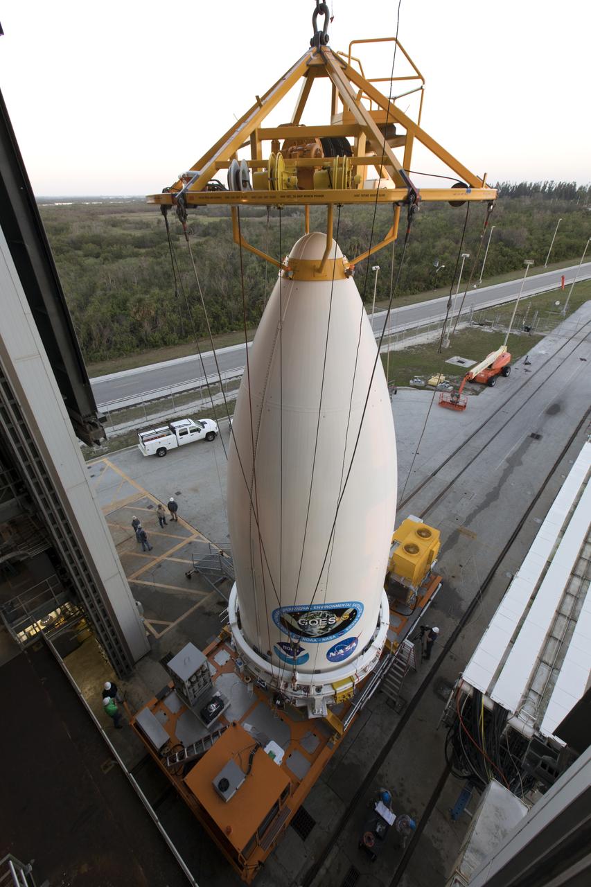 A view from above shows a crane attached to the payload fairing containing NOAA's Geostationary Operational Environmental Satellite-S (GOES-S). The fairing will be lifted and moved into the Vertical Integration Facility at Space Launch Complex 41 at Cape Canaveral Air Force Station in Florida. The fairing will be lifted and mated to the ULA Atlas V rocket. GOES-S is the second in a series of four advanced geostationary weather satellites. The satellite is slated to launch aboard the ULA Atlas V on March 1. 