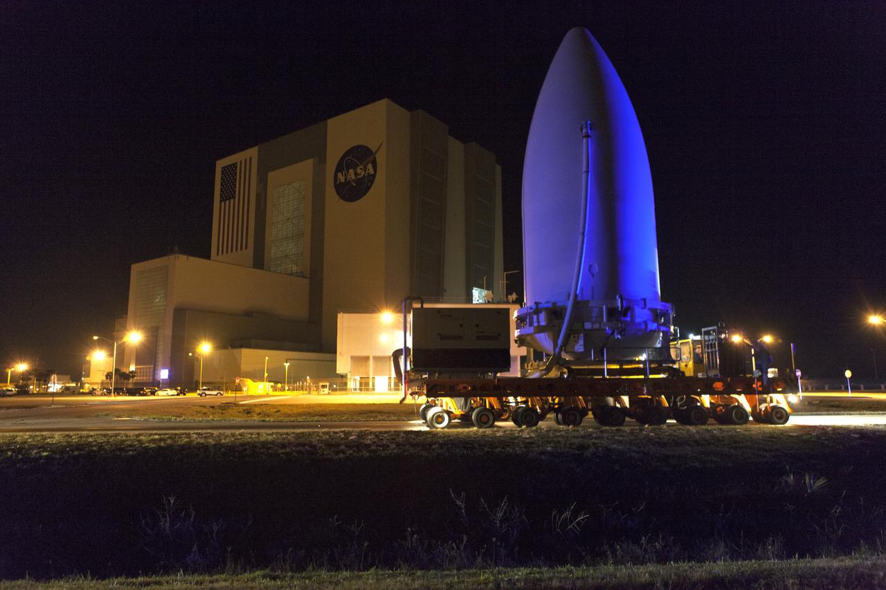 The payload fairing containing NOAA's Geostationary Operational Environmental Satellite-S (GOES-S), secured on a transporter, passes by the Vehicle Assembly Building at NASA's Kennedy Space Center in Florida, on its way to the United Launch Alliance (ULA) Vertical Integration Facility at Space Launch Complex 41 at Cape Canaveral Air Force Station in Florida. The payload fairing will be lifted and mated to the ULA Atlas V rocket. GOES-S is the second in a series of four advanced geostationary weather satellites. GOES-S is slated to launch aboard the ULA Atlas V on March 1.