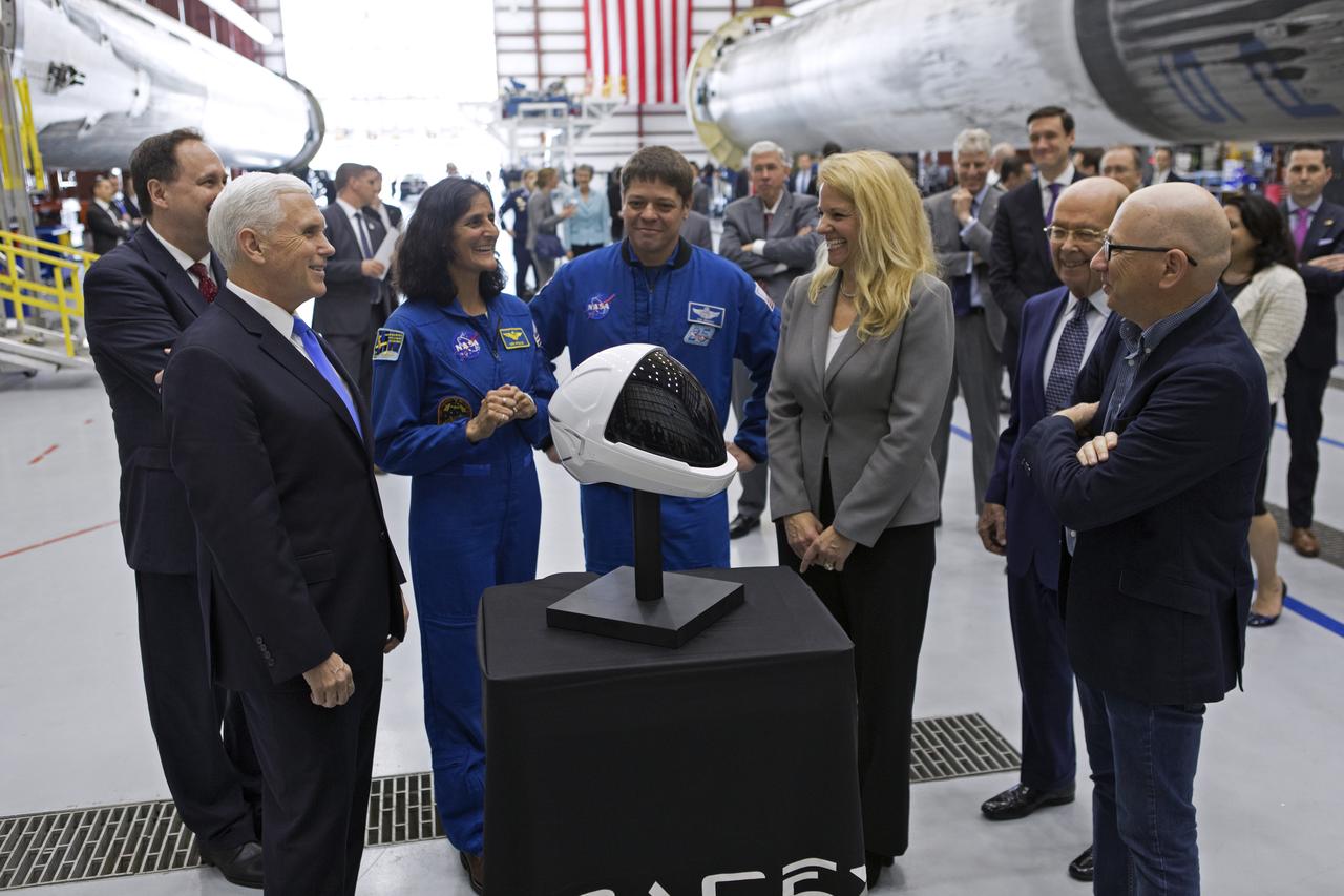 Vice President Mike Pence, left, tours the SpaceX hangar at Launch Complex 39A, at NASA's Kennedy Space Center in Florida, on Feb. 21, 2018. SpaceX officials, along with NASA astronauts Suni Williams and Bob Behnken, examine the type of pressure suit helmet to be worn as crews travel to the International Space Station aboard the company's Crew Dragon spacecraft. During his visit, Pence chaired a meeting of the National Space Council in the high bay of the center's Space Station Processing Facility. The council's role is to advise the president regarding national space policy and strategy, and review the nation's long-range goals for space activities.