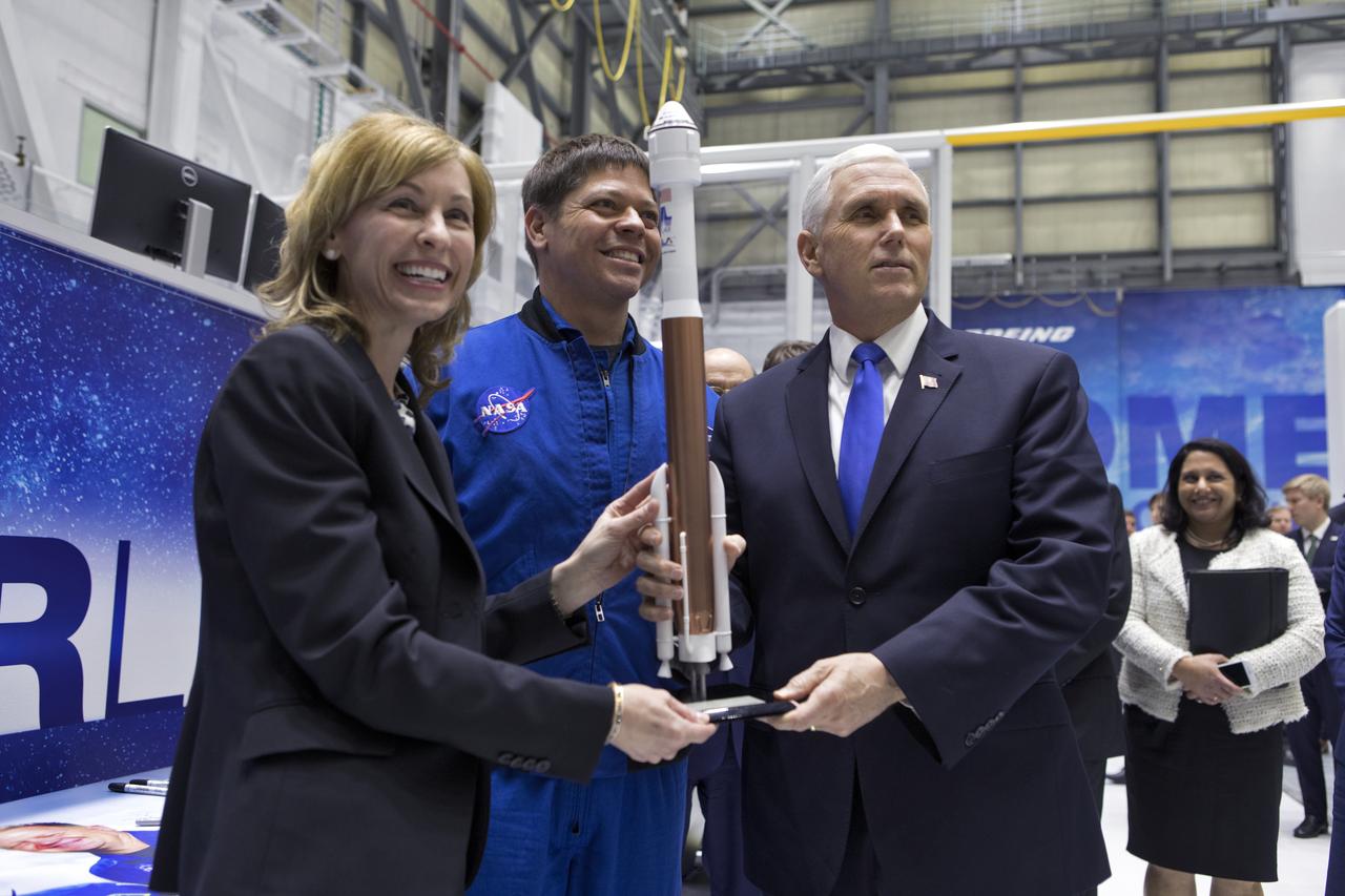 Vice President Mike Pence, right, Boeing President and CEO Leanne Caret, left, and NASA astronaut Bob Behnken, center, view a model of the Boeing Starliner spacecraft and United Launch Alliance Atlas V rocket during a tour of the company’s Commercial Crew and Cargo Processing Facility at NASA's Kennedy Space Center in Florida, on Feb. 21, 2018. During his visit, Pence chaired a meeting of the National Space Council in the high bay of the center's Space Station Processing Facility. The council's role is to advise the president regarding national space policy and strategy, and review the nation's long-range goals for space activities.
