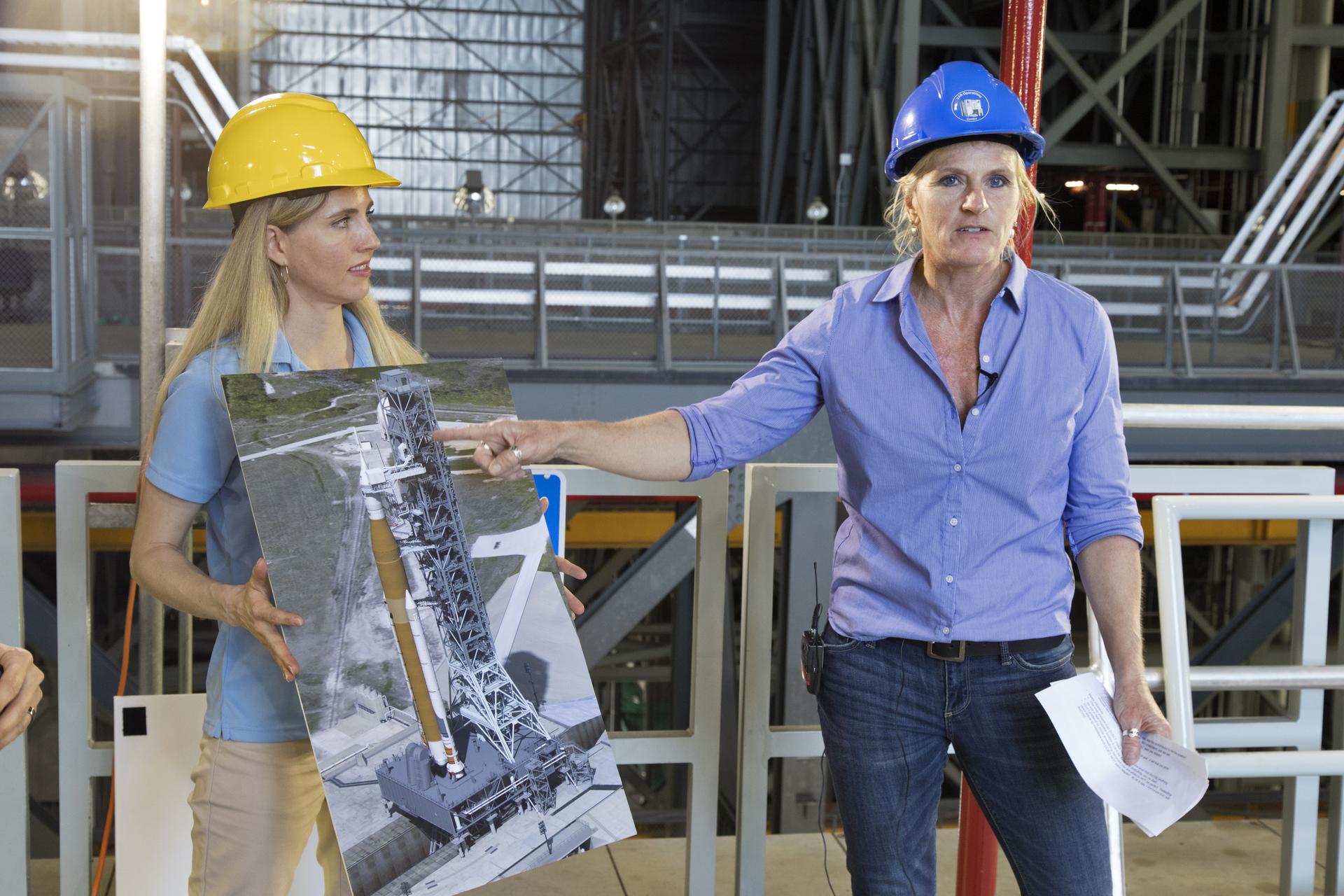 Two women wearing hard hats give a presentation