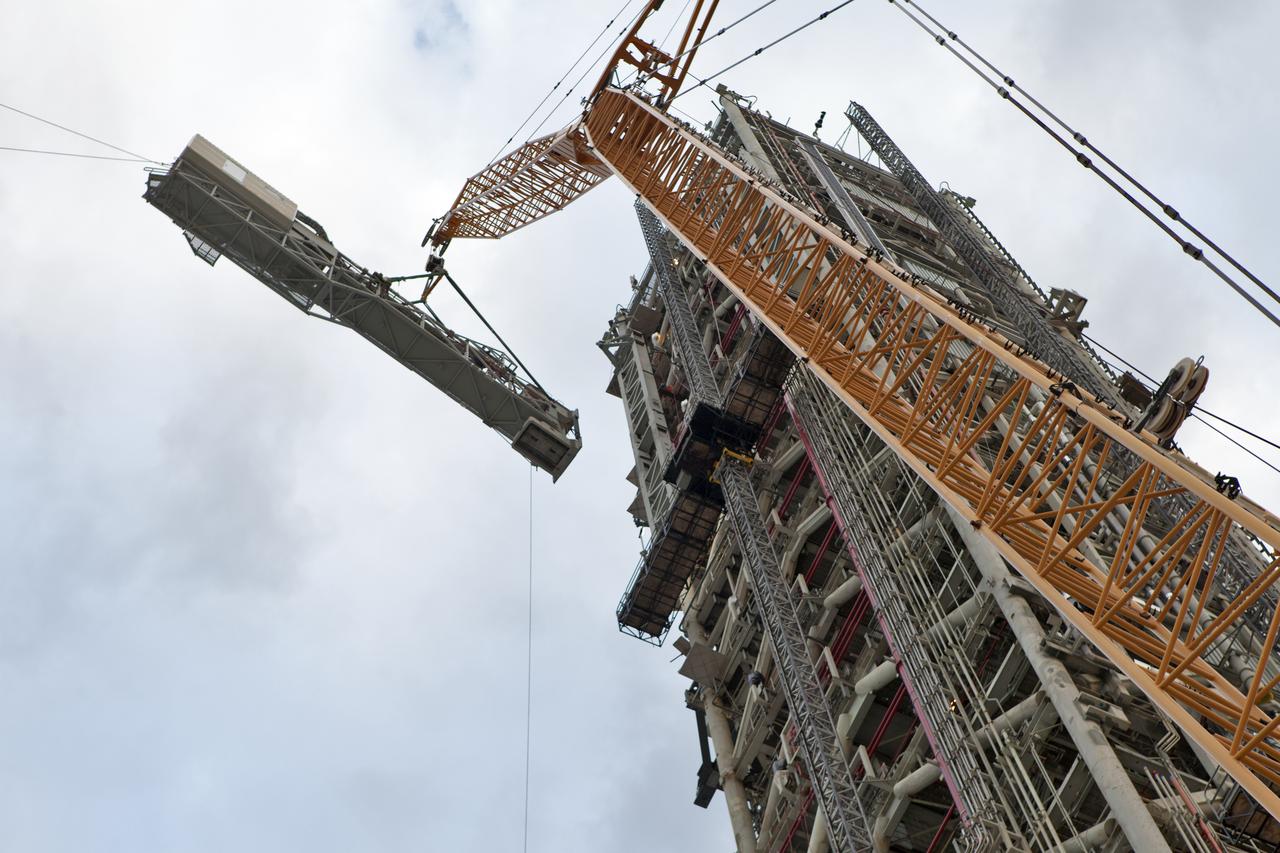 At NASA's Kennedy Space Center in Florida, a crane lifts the Orion crew access arm (CAA) so it can be attached to the mobile launcher (ML). The arm will be installed at about the 274-foot level on the ML tower. NASA's Exploration Ground Systems organization has been overseeing installation of umbilicals and other launch accessories on the 380-foot-tall ML in preparation for stacking the first launch of the Space launch System (SLS), rocket with an Orion spacecraft. The CAA is designed to rotate from its retracted position and line up with Orion's crew hatch providing entry for astronauts and technicians.