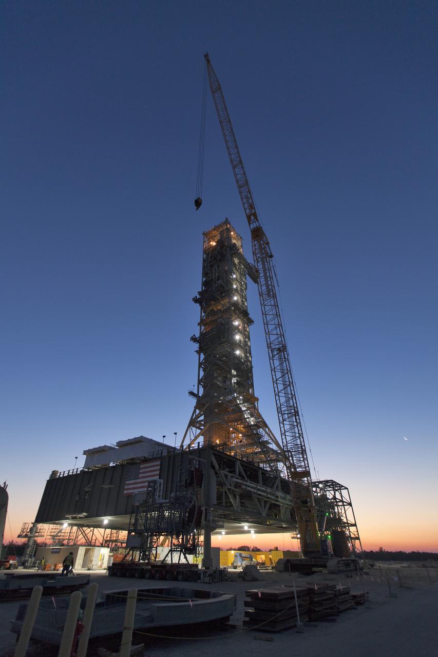 A colorful sunrise serves as the backdrop for the mobile launcher (ML) at NASA's Kennedy Space Center in Florida. Several launch umbilicals have been installed on the ML tower. Exploration Ground Systems is overseeing installation of umbilicals and launch accessories on the ML to prepare for the first integrated test flight of the Orion spacecraft on the agency's Space Launch System rocket on Exploration Mission-1. 