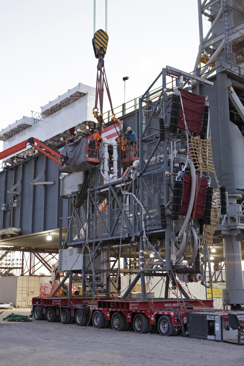 Construction workers with JP Donovan attach a heavy-lift crane to the Interim Cryogenic Propulsion Stage Umbilical (ICPSU) to prepare for lifting and installation on the mobile launcher (ML) tower at NASA's Kennedy Space Center in Florida. The last of the large umbilicals to be installed, the ICPSU will provide super-cooled hydrogen and liquid oxygen to the Space Launch System (SLS) rocket's interim cryogenic propulsion stage, or upper stage, at T-0 for Exploration Mission-1. The umbilical will be located at about the 240-foot-level of the ML and will supply fuel, oxidizer, gaseous helium, hazardous gas leak detection, electrical commodities and environment control systems to the upper stage of the SLS rocket during launch. Exploration Ground Systems is overseeing installation of the umbilicals on the ML.
