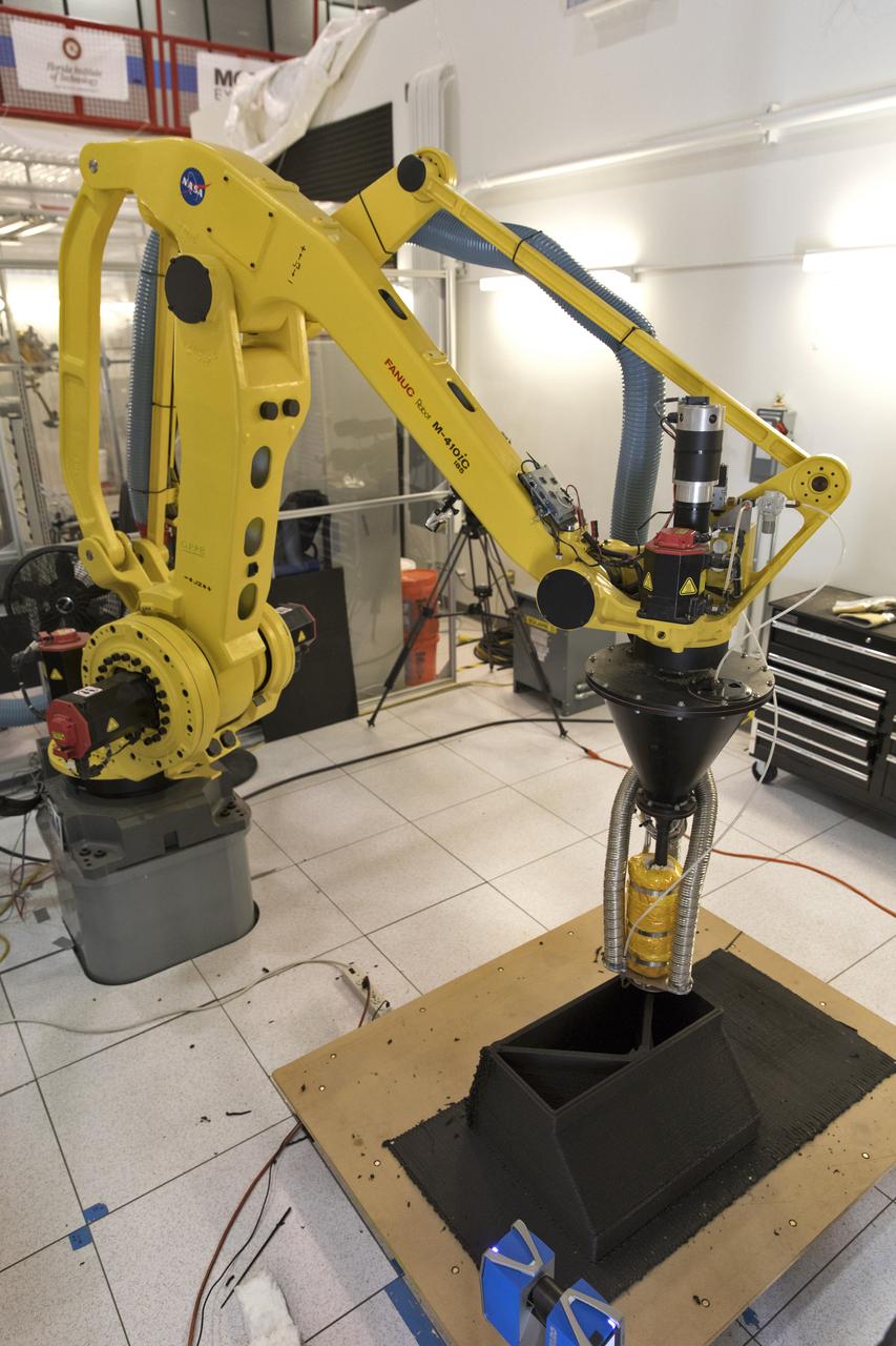 Researchers demonstrate a Zero Launch Mass 3-D printer in Swamp Works at NASA's Kennedy Space Center in Florida. The printer can be used for construction projects on the Moon and Mars. Zero launch mass refers to the fact that the printer uses pellets made from simulated lunar regolith, or dirt, and polymers. This will prove that space explorers can use resources at their destination instead of taking everything with them, saving them launch mass and money. The Kennedy team is working with Marshall Space Flight Center in Huntsville, Alabama, and the U.S. Army Corps of Engineers to develop a system that can 3-D print barracks in remote locations on Earth, using the resources they have where they are. 