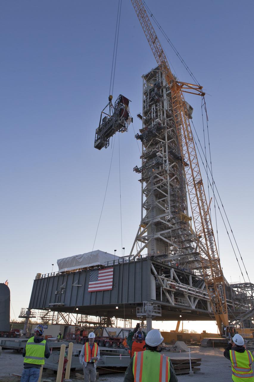 A heavy-lift crane slowly lifts the Interim Cryogenic Propulsion Stage Umbilical (ICPSU) high up for installation on the tower of the mobile launcher (ML) at NASA's Kennedy Space Center in Florida. The last of the large umbilicals to be installed, the ICPSU will provide super-cooled hydrogen and liquid oxygen to the Space Launch System (SLS) rocket's interim cryogenic propulsion stage, or upper stage, at T-0 for Exploration Mission-1. The umbilical is located at about the 240-foot-level of the mobile launcher and will supply fuel, oxidizer, gaseous helium, hazardous gas leak detection, electrical commodities and environment control systems to the upper stage of the SLS rocket during launch. Exploration Ground Systems is overseeing installation of the umbilicals on the ML. 