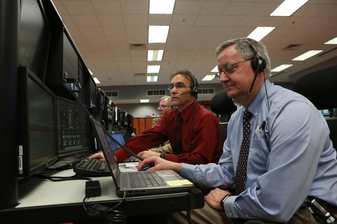 Test Project Engineer Rick Brown, left, and Master Console Operator Jason Robinson, both with Jacobs, monitor operations from their consoles in Firing Room 1 at the Kennedy Space Center's Launch Control Center during a countdown simulation for Exploration Mission 1. It was the agency's first simulation of a portion of the countdown for the first launch of a Space Launch System rocket and Orion spacecraft that will eventually take astronauts beyond low-Earth orbit to destinations such as the Moon and Mars.