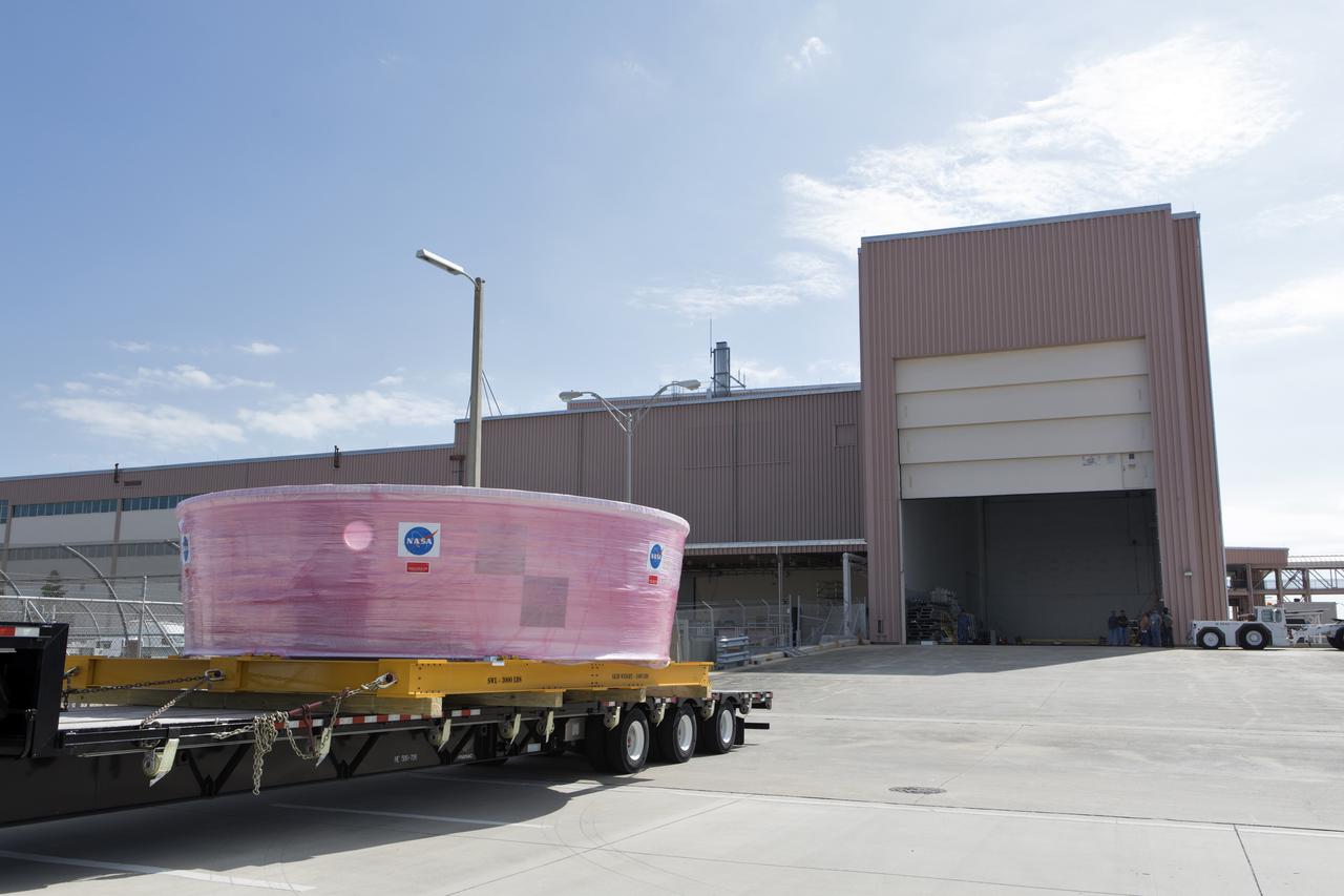 The Orion Stage Adapter (OSA), secured on flatbed transporter, arrives at the entrance to the airlock at the Space Station Processing Facility (SSPF) at NASA's Kennedy Space Center in Florida. The OSA is the second flight-hardware section of the agency's Space Launch System (SLS) rocket to arrive at Kennedy. The OSA will connect the Orion spacecraft to the upper part of the SLS, the interim cryogenic propulsion stage (ICPS). Both the OSA and ICPS are being stored for processing in the SSPF in preparation for Exploration Mission-1, the first uncrewed, integrated launch of the SLS rocket and Orion spacecraft. 