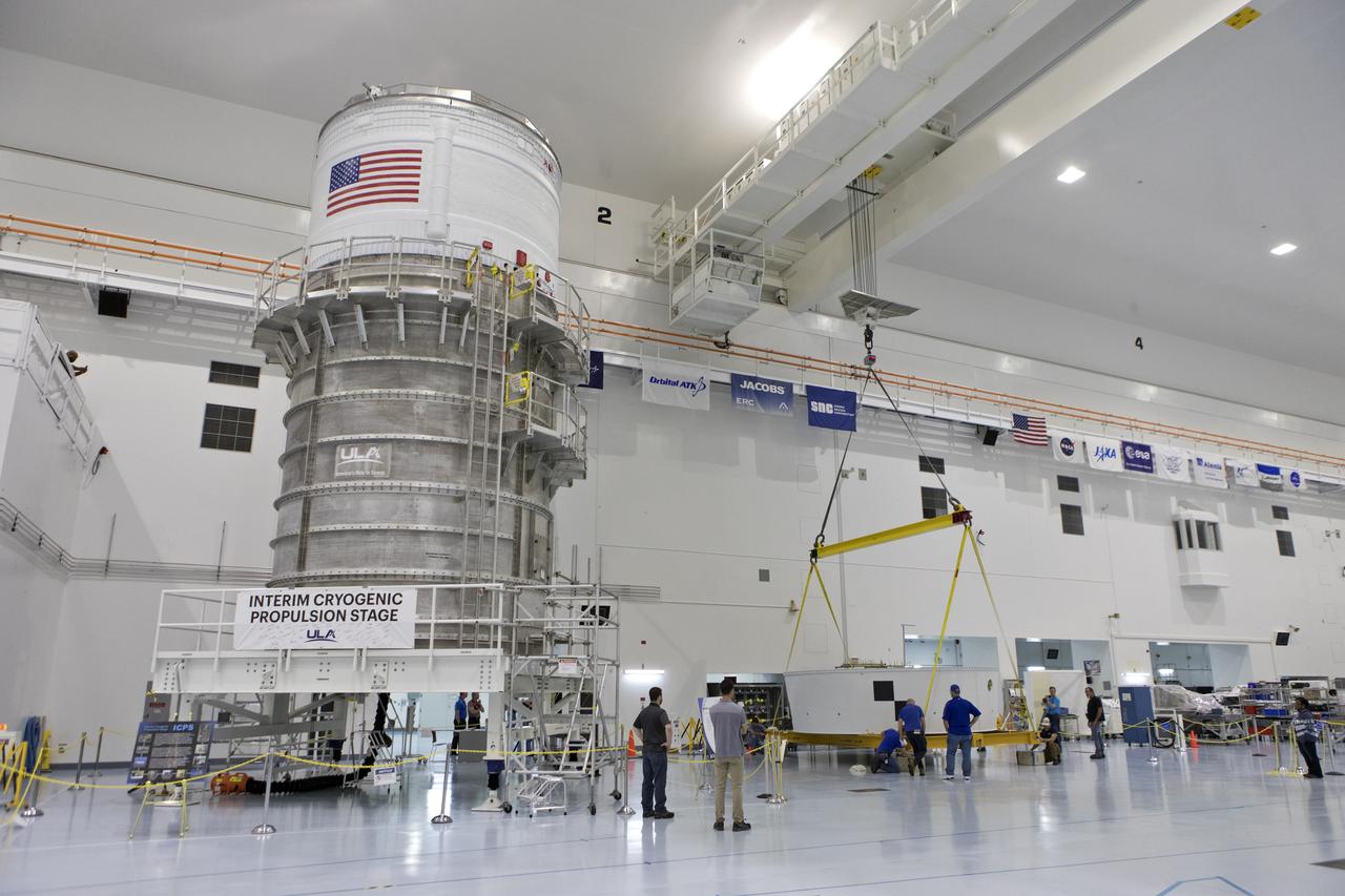 The Orion Stage Adapter (OSA) is lowered by crane into a work area in the high bay of the Space Station Processing Facility (SSPF) at NASA's Kennedy Space Center in Florida. The OSA is the second flight-hardware section of the agency's Space Launch System (SLS) rocket to arrive at Kennedy. The OSA will connect the Orion spacecraft to the upper part of the SLS, the interim cryogenic propulsion stage (ICPS). Both the OSA and ICPS, at left, are being stored for processing in the SSPF in preparation for Exploration Mission-1, the first uncrewed, integrated launch of the SLS rocket and Orion spacecraft. 