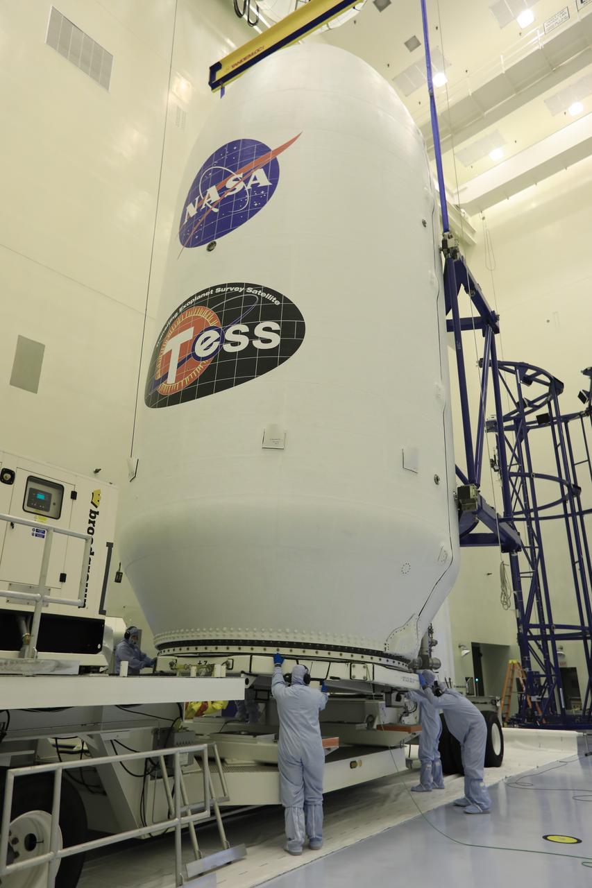 Inside the Payload Hazardous Servicing Facility at NASA's Kennedy Space Center in Florida, technicians assist as the SpaceX payload fairing containing the agency's Transiting Exoplanet Survey Satellite (TESS) is lowered by crane onto a transporter. The fairing will be moved to Space Launch Complex 40 at Cape Canaveral Air Force Station. TESS is scheduled to launch on the SpaceX Falcon 9 rocket at 6:32 p.m. EDT on April 16. The satellite is the next step in NASA's search for planets outside our solar system, known as exoplanets. TESS is a NASA Astrophysics Explorer mission led and operated by MIT in Cambridge, Massachusetts, and managed by NASA’s Goddard Space Flight Center in Greenbelt, Maryland. Dr. George Ricker of MIT’s Kavli Institute for Astrophysics and Space Research serves as principal investigator for the mission. Additional partners include Orbital ATK, NASA’s Ames Research Center, the Harvard-Smithsonian Center for Astrophysics and the Space Telescope Science Institute. More than a dozen universities, research institutes and observatories worldwide are participants in the mission. NASA’s Launch Services Program is responsible for launch management.