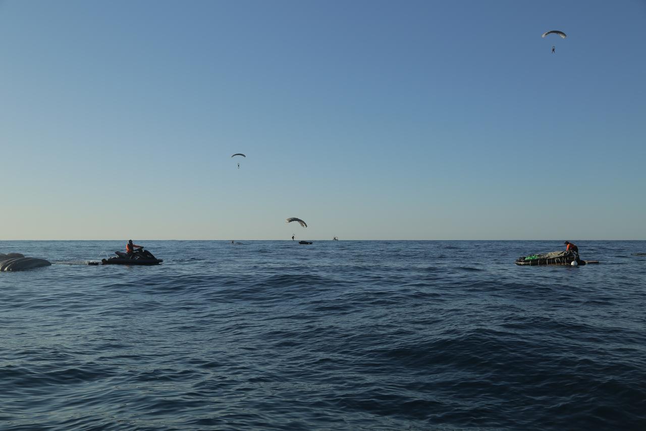 Pararescue specialists from the 304th Rescue Squadron, located in Portland, Oregon and supporting the 45th Operations Group’s Detachment 3, based out of Patrick Air Force Base, deploy their parachutes and prepare to touch down on the Atlantic Ocean surface during an April astronaut rescue exercise with NASA’s Commercial Crew Program and SpaceX off of Florida’s eastern coast. The pararescue specialists, also known as “Guardian Angels,” jumped from military aircraft and simulated a rescue operation to demonstrate their ability to safely remove crew from the SpaceX Crew Dragon in the unlikely event of an emergency landing.
