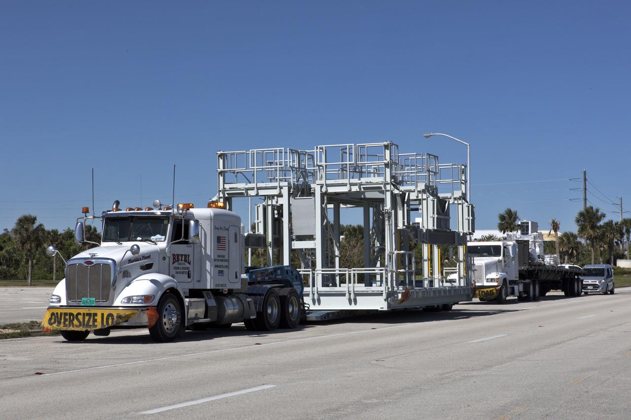 A new service platform for NASA's Space Launch System booster engines, secured on a flatbed truck, is on its way to the agency's Kennedy Space Center in Florida. It was transported from fabricator Met-Con Inc. in Cocoa, Florida. The platform will be delivered to the Vehicle Assembly Building, where it will be stored and used for processing and checkout of the engines for the rocket's twin five-segment solid rocket boosters for Exploration Mission-1 (EM-1). During EM-1, an uncrewed Orion spacecraft will launch on the SLS to a stable orbit beyond the Moon and return to Earth for a splashdown in the Pacific Ocean.