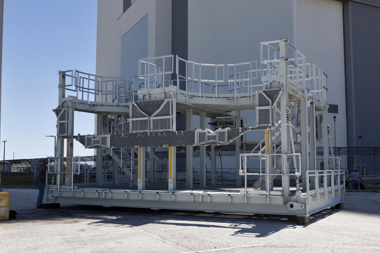A new service platform for NASA's Space Launch System booster engines is being prepared for the move into the Vehicle Assembly Building (VAB) at the agency's Kennedy Space Center in Florida. The platform was transported from fabricator Met-Con Inc. in Cocoa, Florida. It will be stored in the VAB, and used for processing and checkout of the engines for the rocket's twin five-segment solid rocket boosters for Exploration Mission-1.  EM-1 will launch an uncrewed Orion spacecraft to a stable orbit beyond the Moon and bring it back to Earth for a splashdown in the Pacific Ocean.